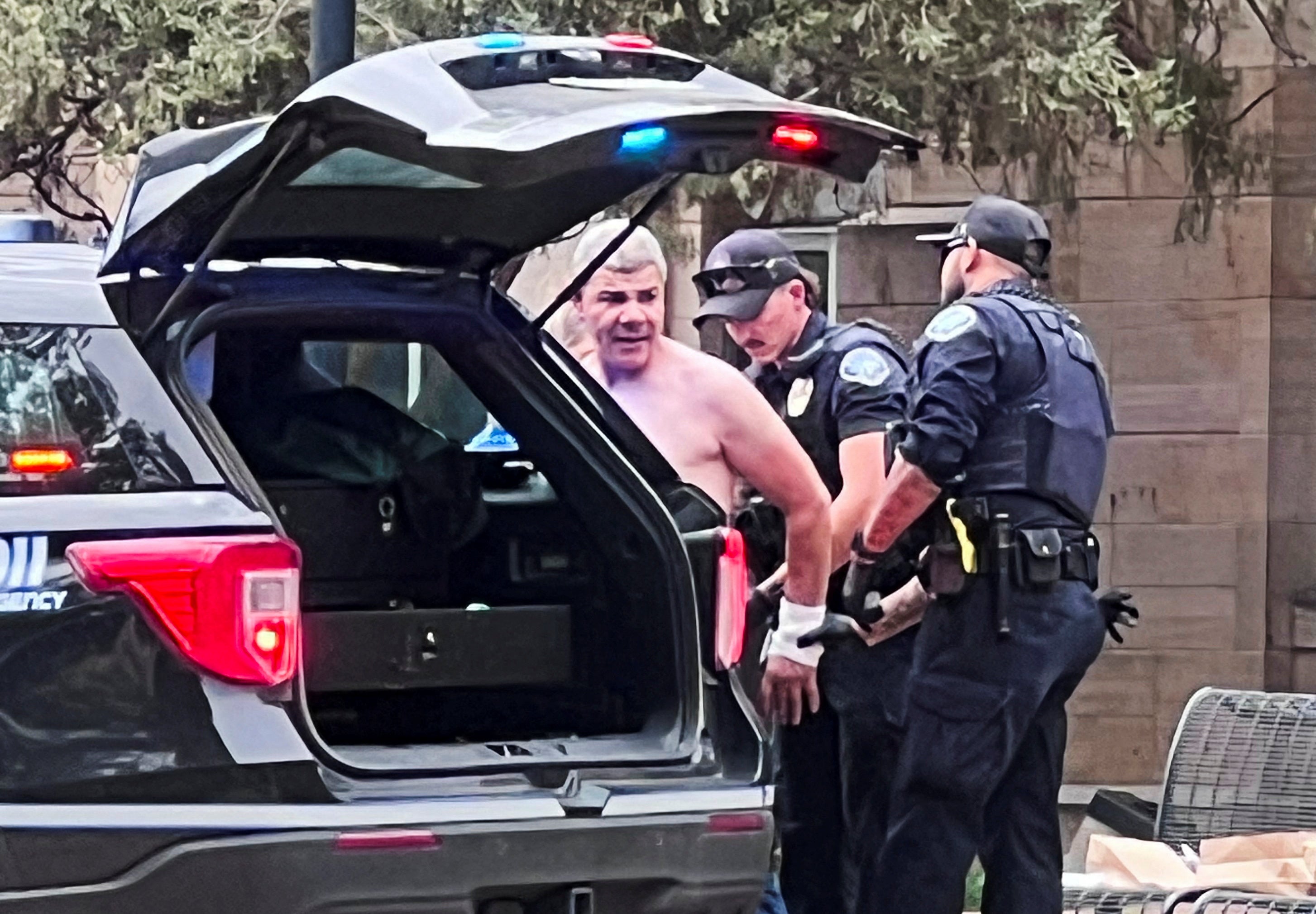 Law enforcement officers detain a suspect following the attack
