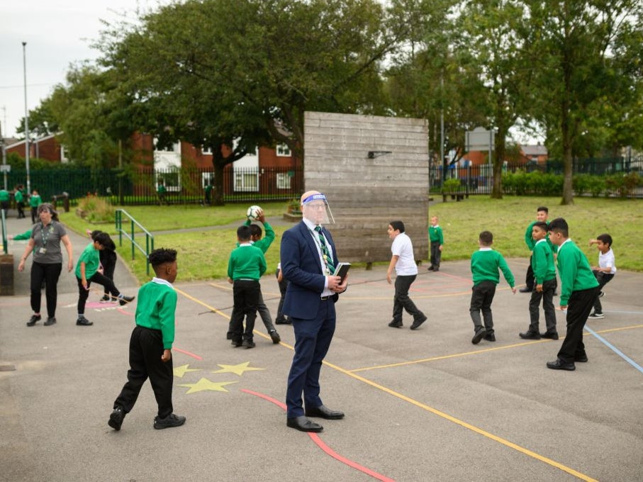 The vice principal wears a PPE face shield in the playground at Greenacres Primary Academy in Oldham