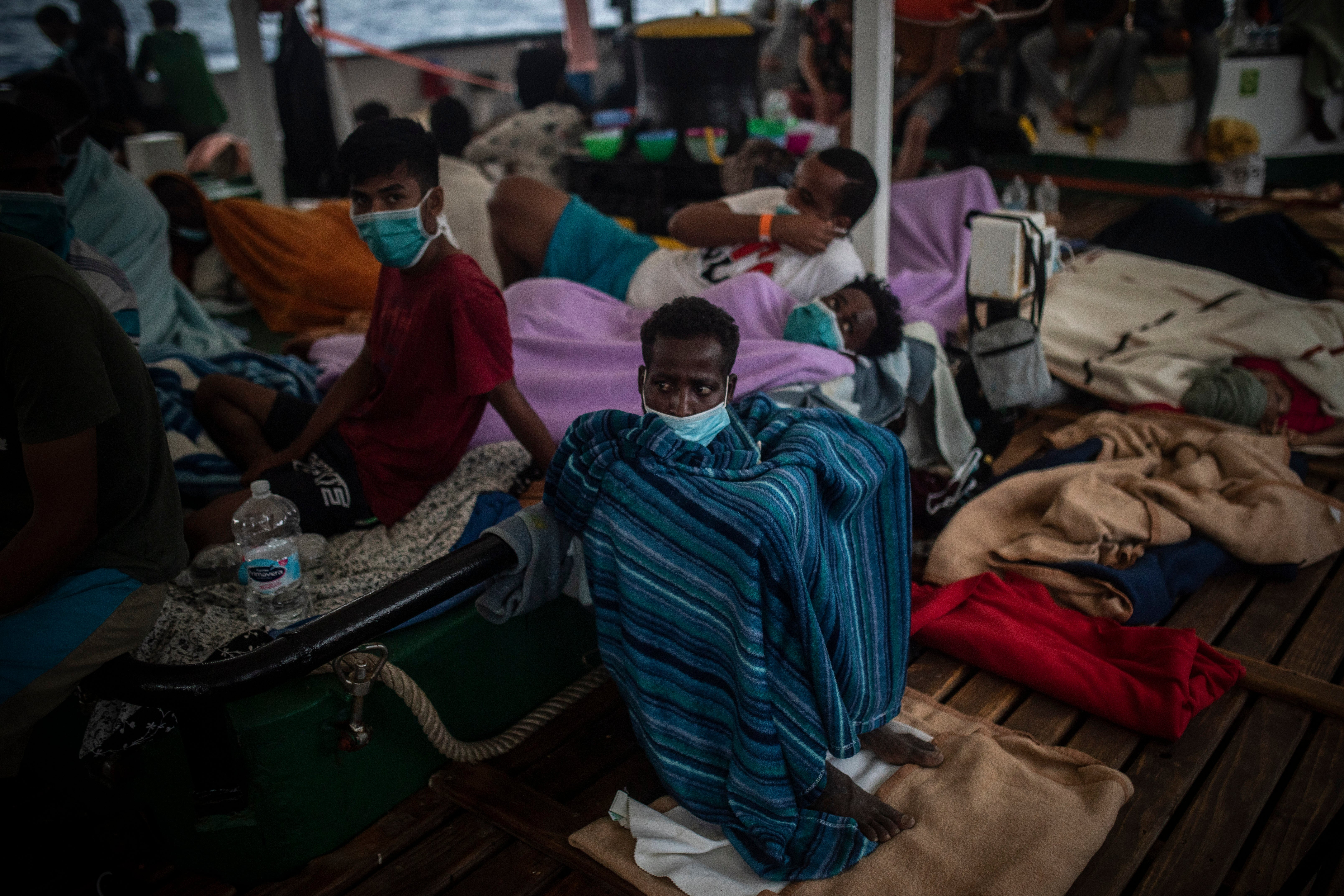 Migrants are rescued after trying to flee Libya on a precarious wooden boat