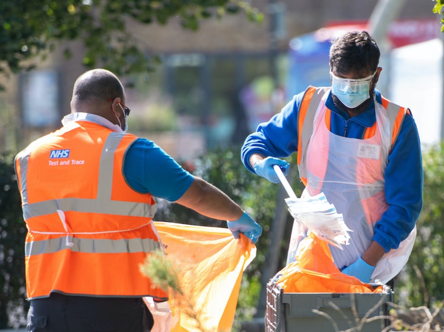 A member of staff handles completed test kits at a Coronavirus testing centre in Southwark, south London