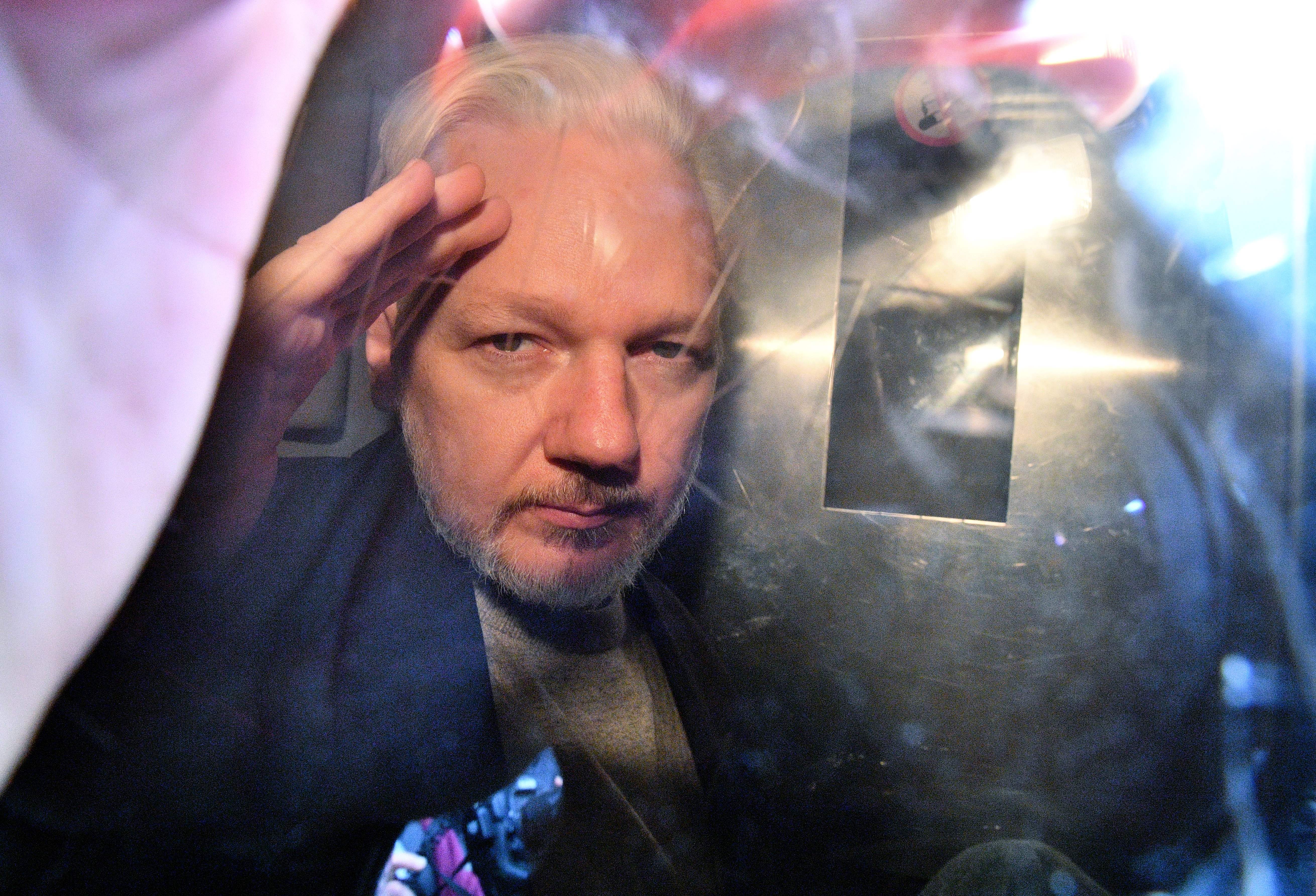 Assange gestures from the window of a prison van as he is driven out of Southwark Crown Court in 2019. He was sentenced to 50 weeks in prison for breaching his bail conditions in 2012