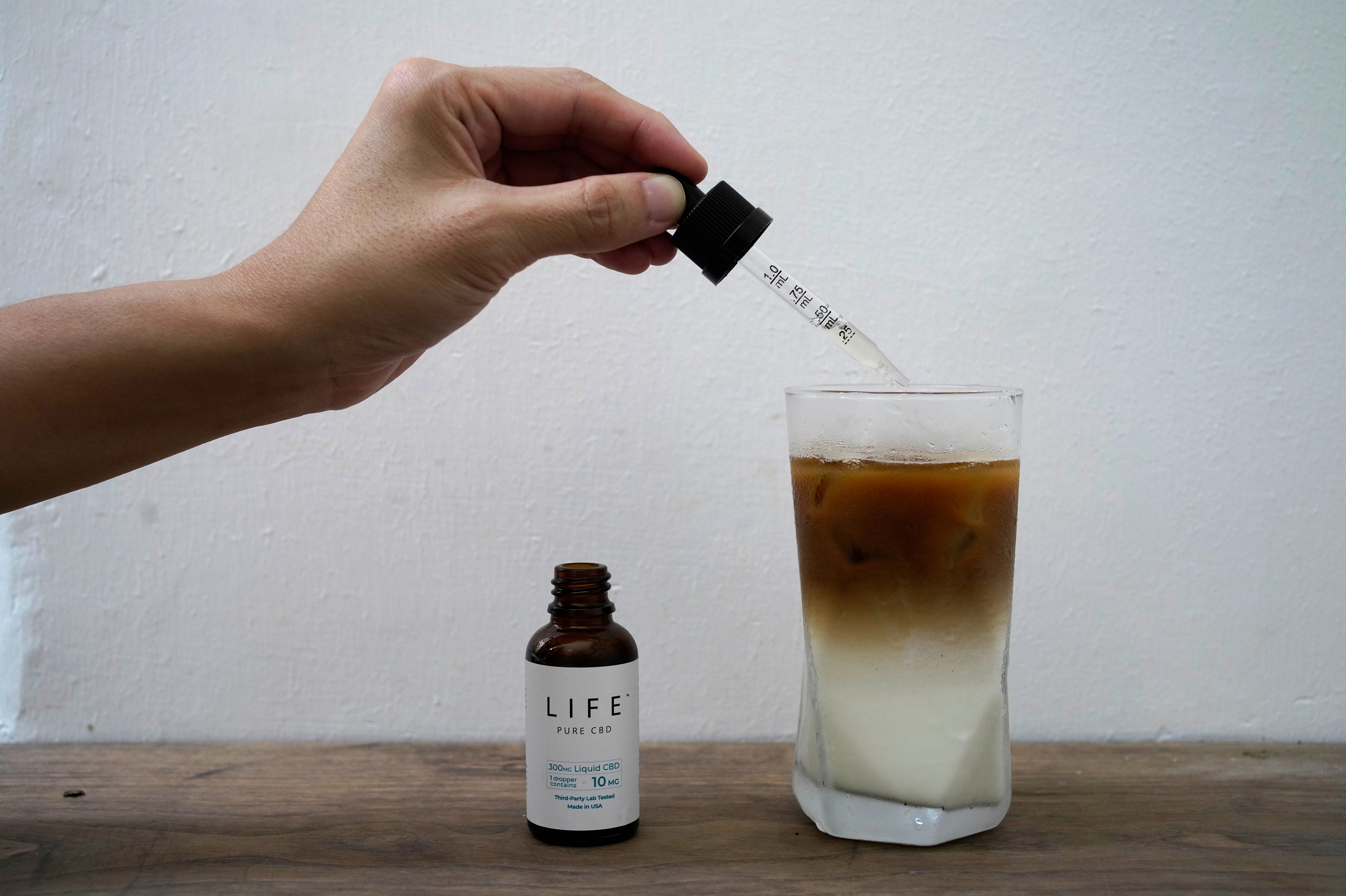 An employee adds drops of water-soluble CBD, or cannabidiol, an essential component of medical marijuana, into a coffee glass at the Found Cafe in Hong Kong