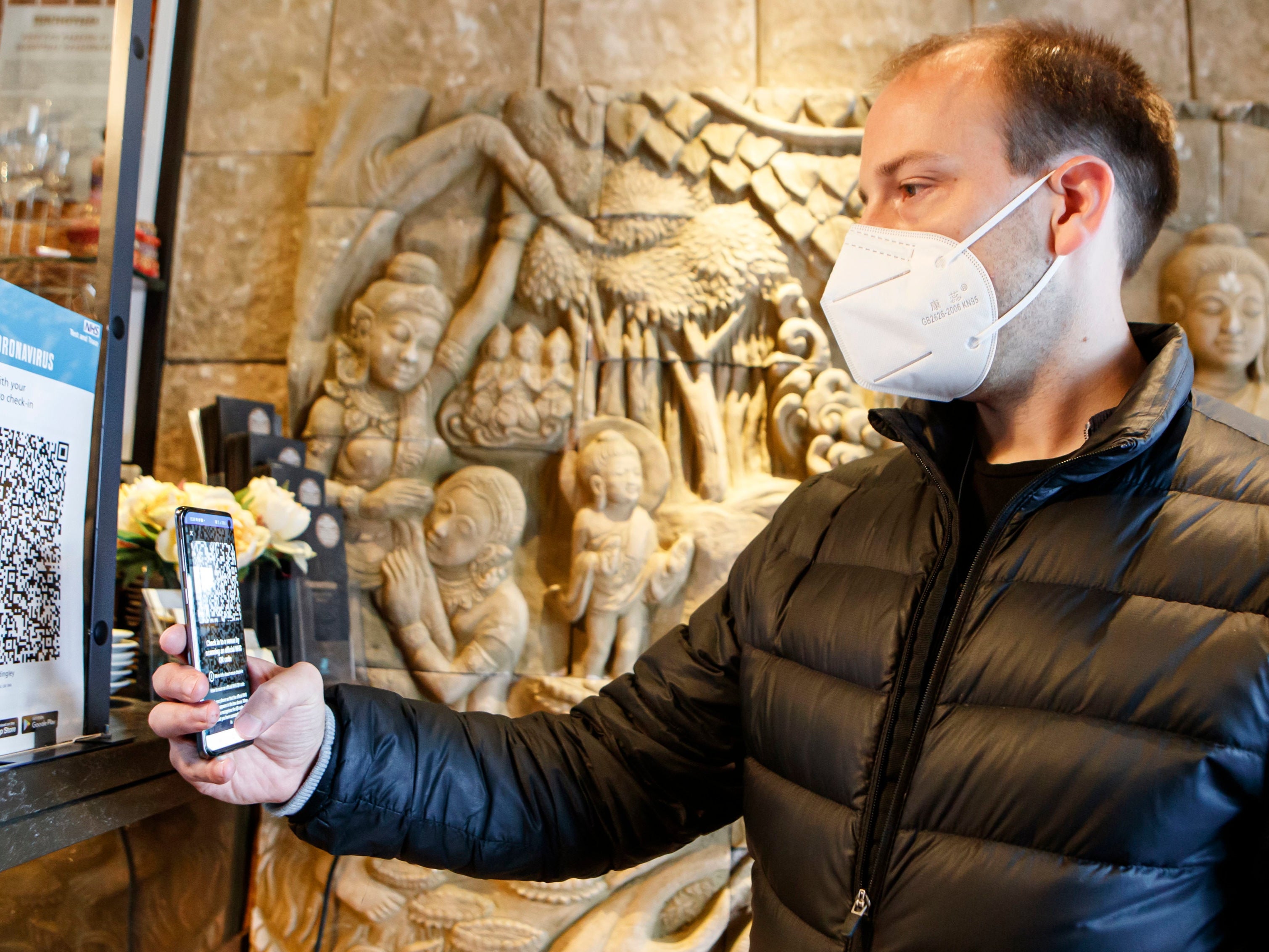 Christopher Hammond, director of the Sukhothai Thai restaurant in Leeds, uses the Venue Check-in feature of the new NHS Covid-19 mobile phone app. 