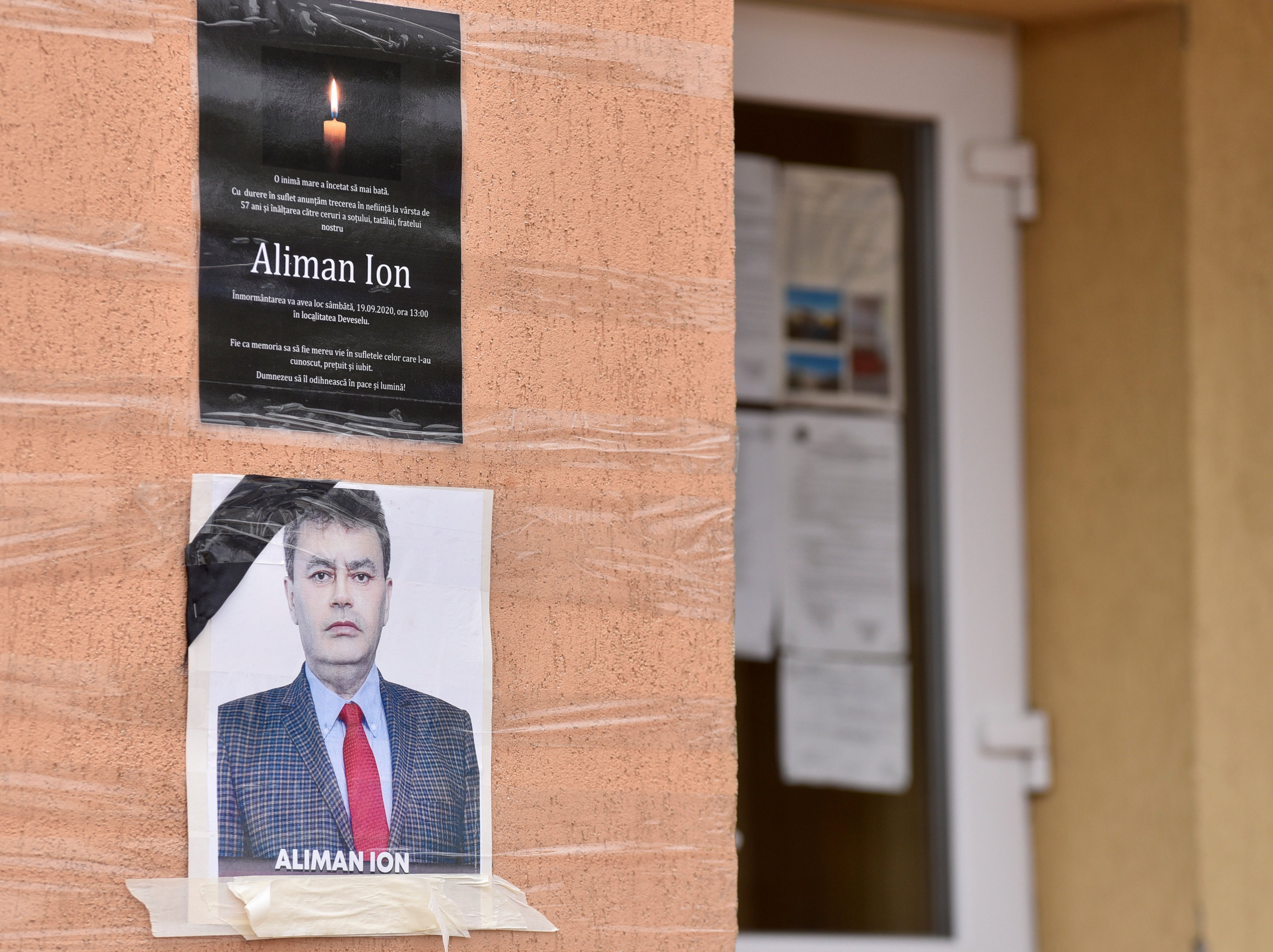 An obituary photo of former mayor Aliman Ion is taped onto the walls of the city hall in Deveselu, southern Romania