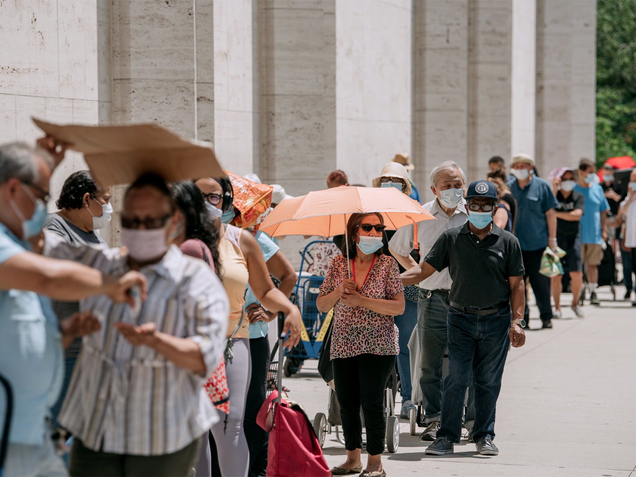 New Yorkers in need wait in a long line to receive free produce, dry goods, and meat at a Food Bank For New York City distribution event at Lincoln Center on July 29, 2020