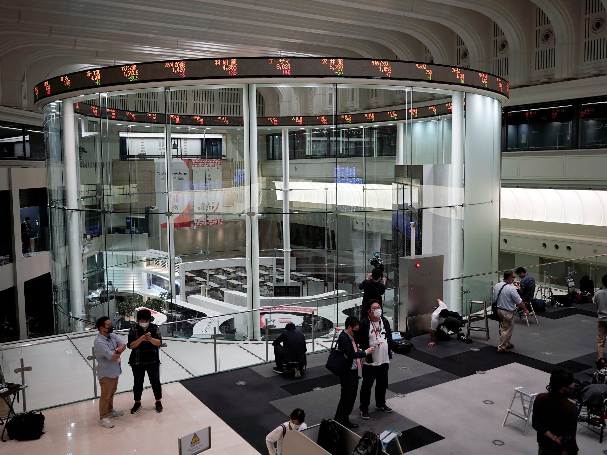 Journalists film an electronic stock board showing reopened Japan's Nikkei 225 index at Tokyo Stock Exchange in Tokyo Friday, Oct. 2, 2020. Tokyo's market resumed trading Friday after a full-day outage due to a malfunction in its computer systems