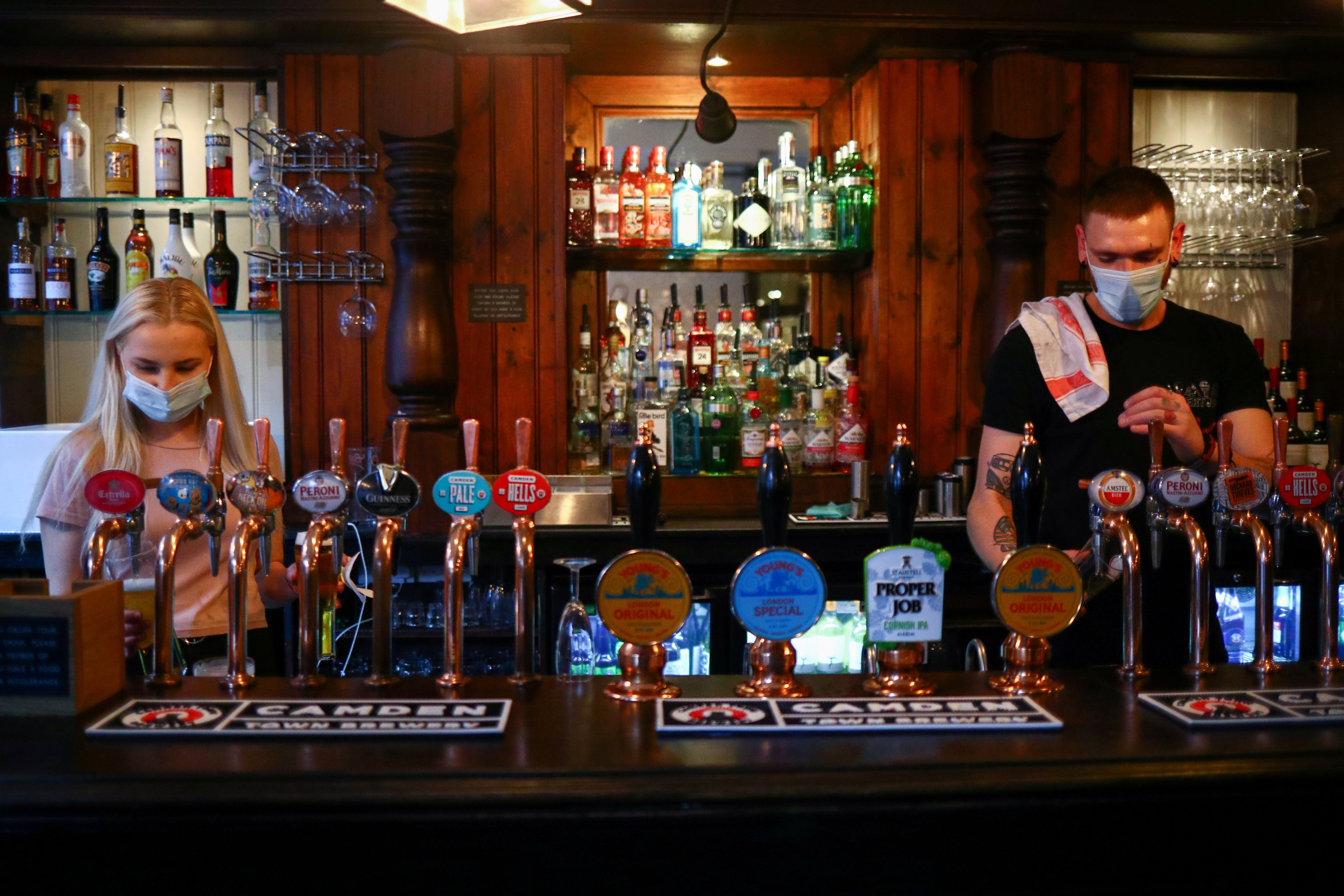 Staff pour drinks at a pub in London Bridge on 24 September, the day the 10pm curfew was introduced