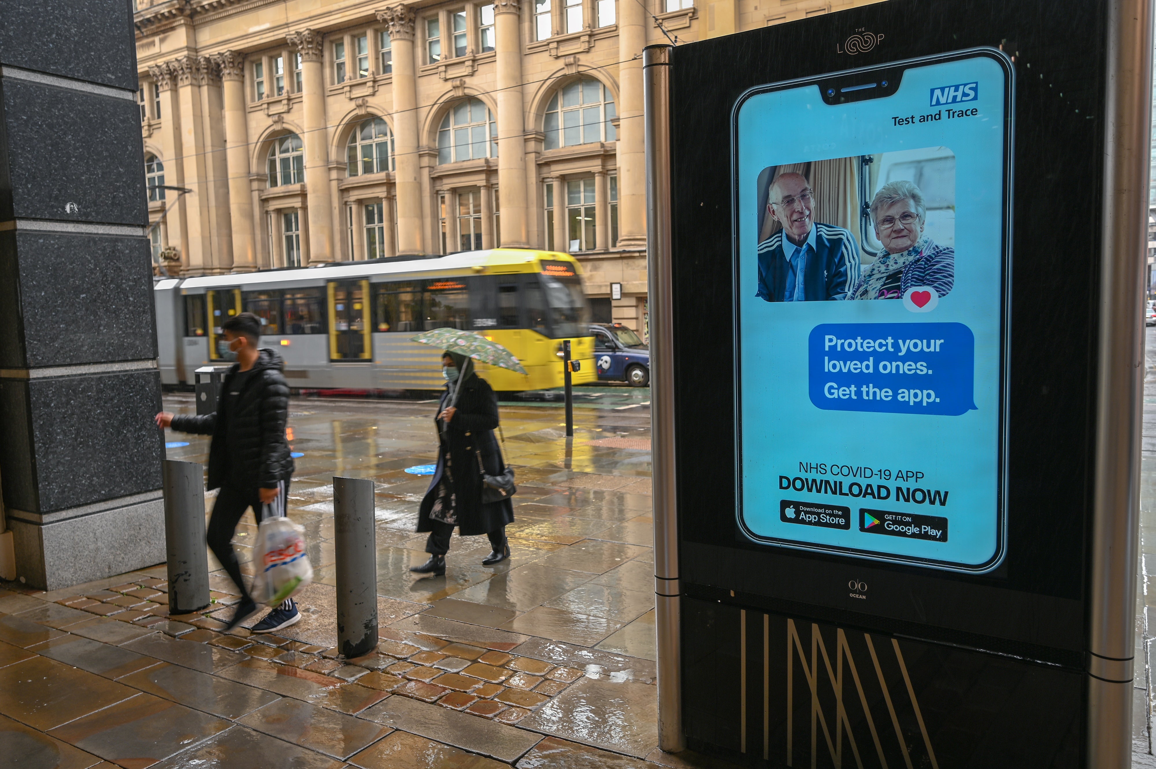 An electronic sign reminds pedestrians to download the NHS Test and Trace app, which has also been heavily criticised