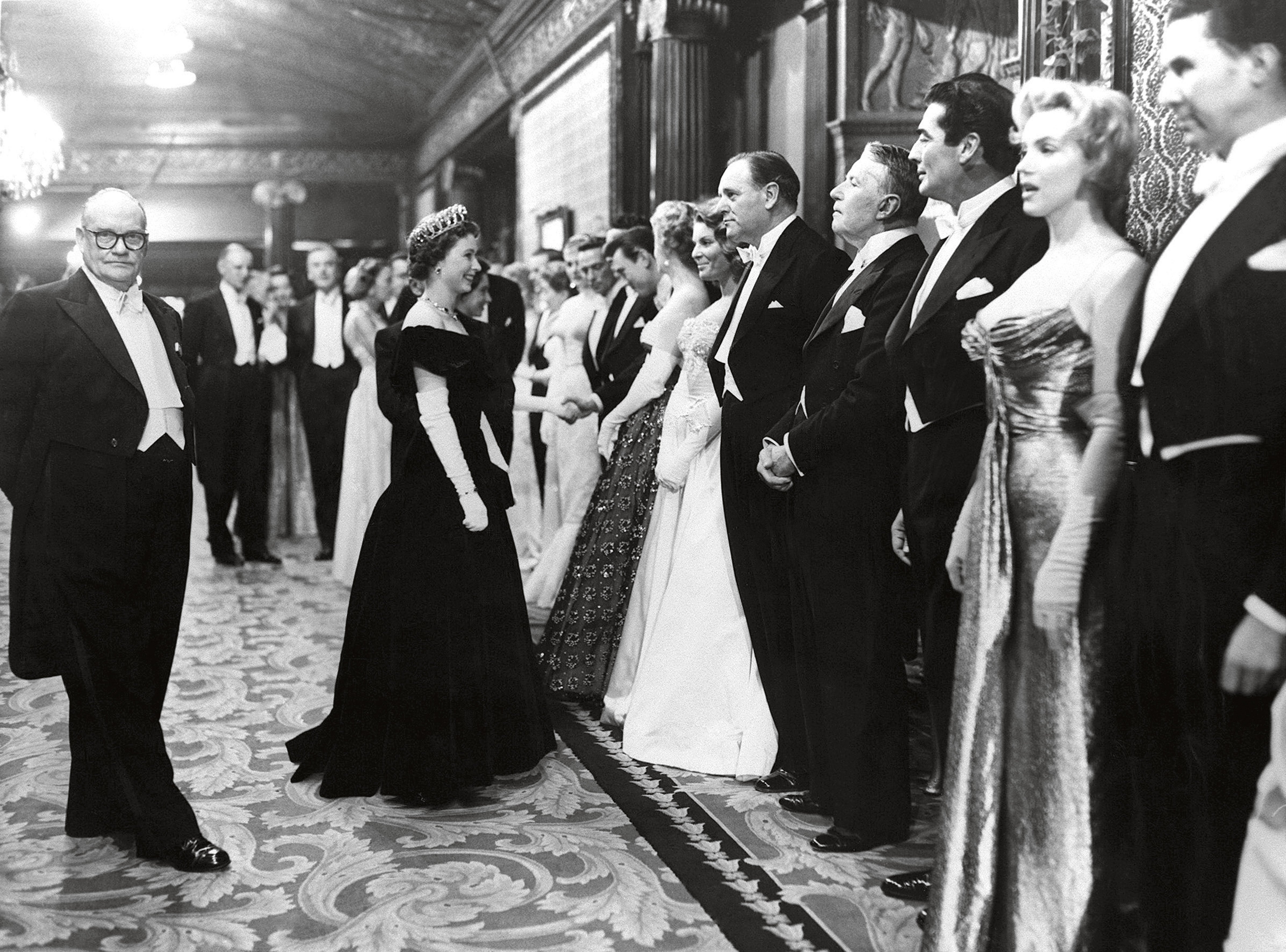 While in England ﬁlming The Prince and the Showgirl with Sir Laurence Olivier, Hollywood screen idol Marilyn Monroe was among the star guests invited to meet the Queen at the London première of The Battle of the River Plate on 29 October 1956.