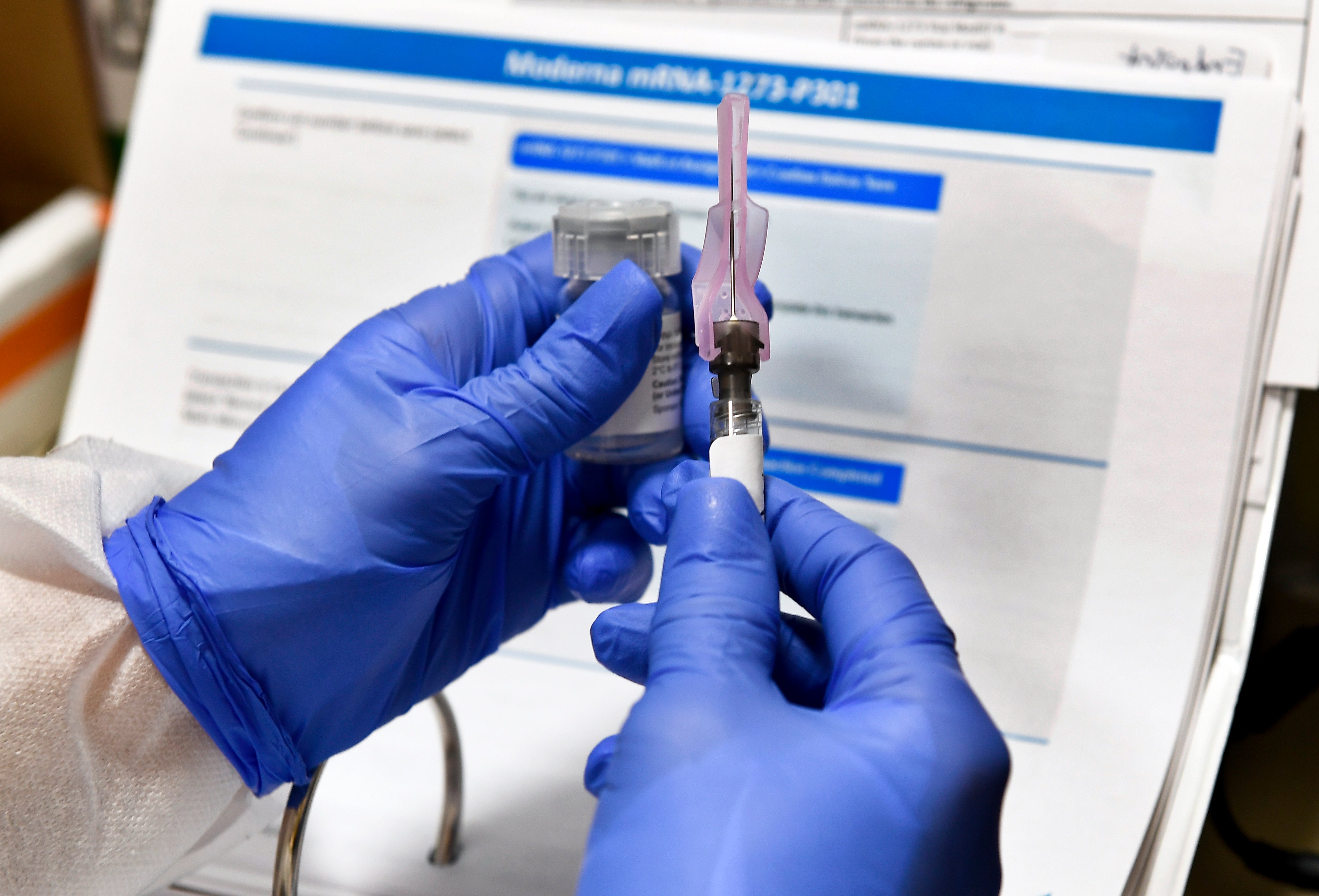 Nurse Kathe Olmstead prepares a shot that is part of a possible COVID-19 vaccine, developed by the National Institutes of Health and Moderna Inc