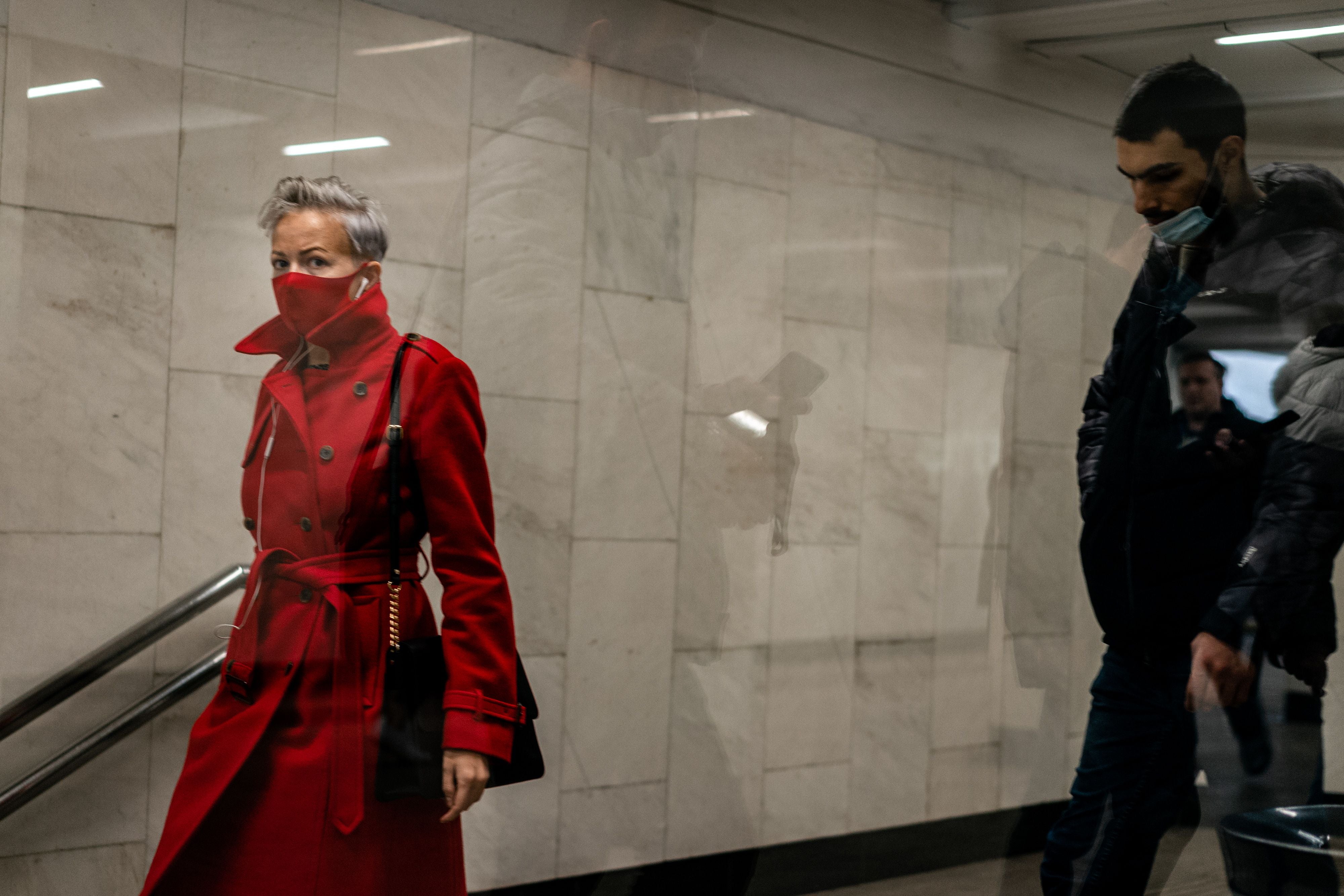 Commuters wearing face masks as a protection against the coronavirus disease walk at a metro station in Moscow