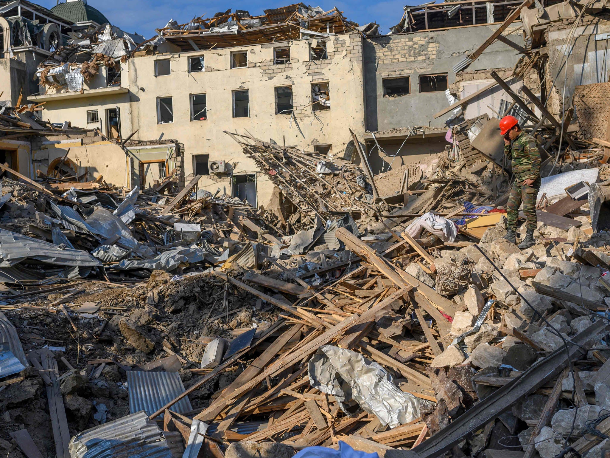 Rescuers search for survivors at site hit by a rocket during the fighting between Armenia and Azerbaijan