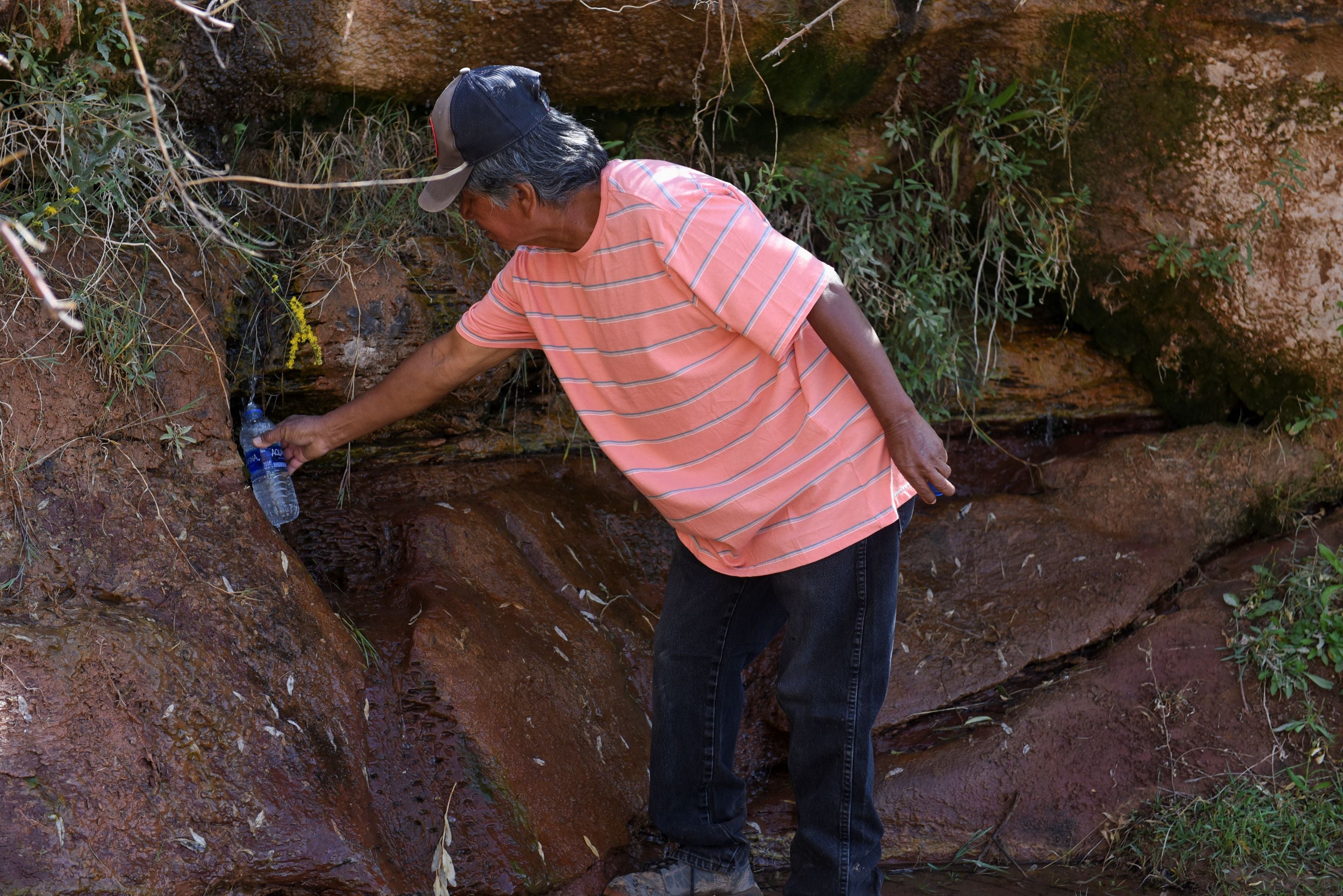 Glen John, 65, catches water from a natural spring