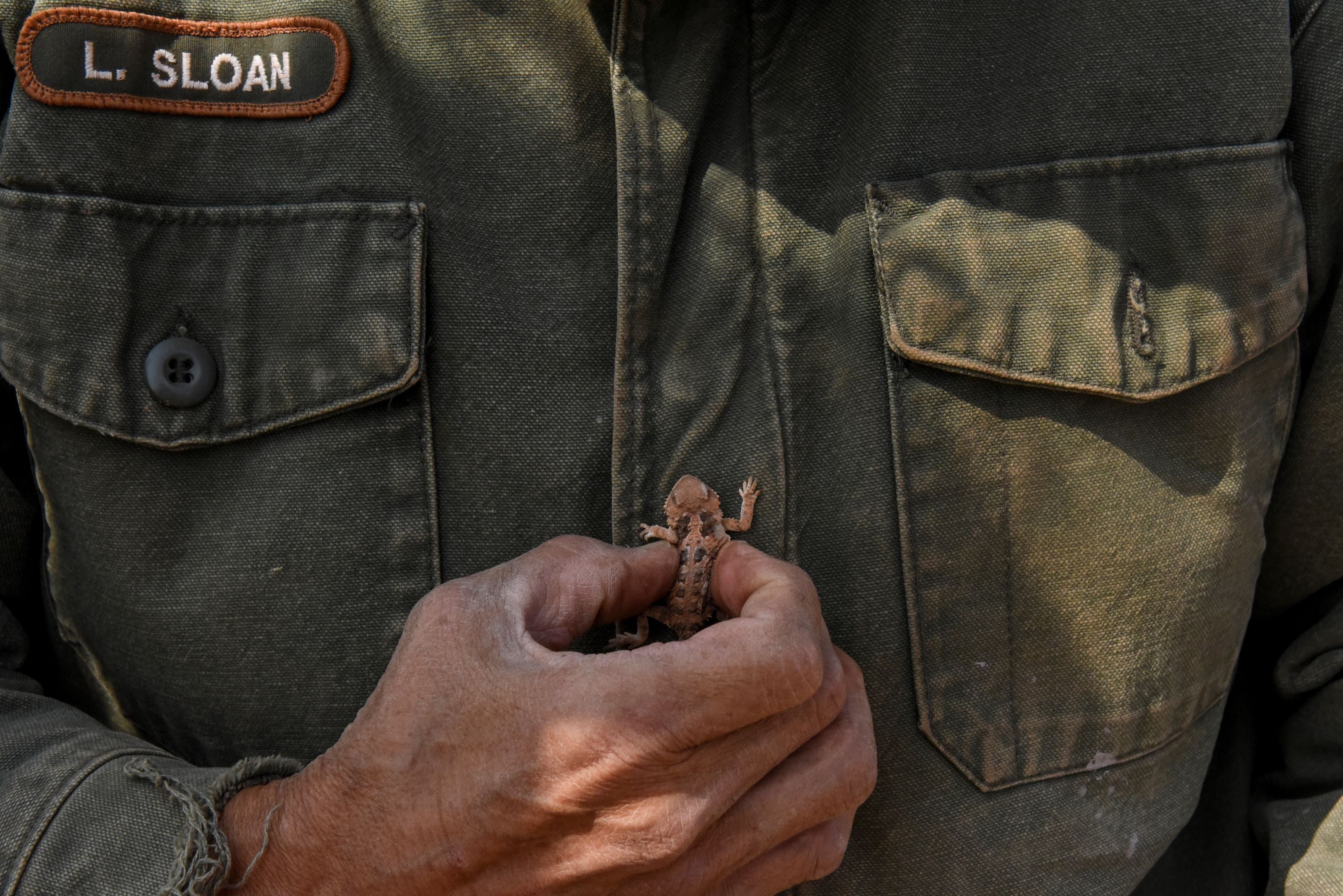 Leonard Sloan prays for rain while holding a horned toad