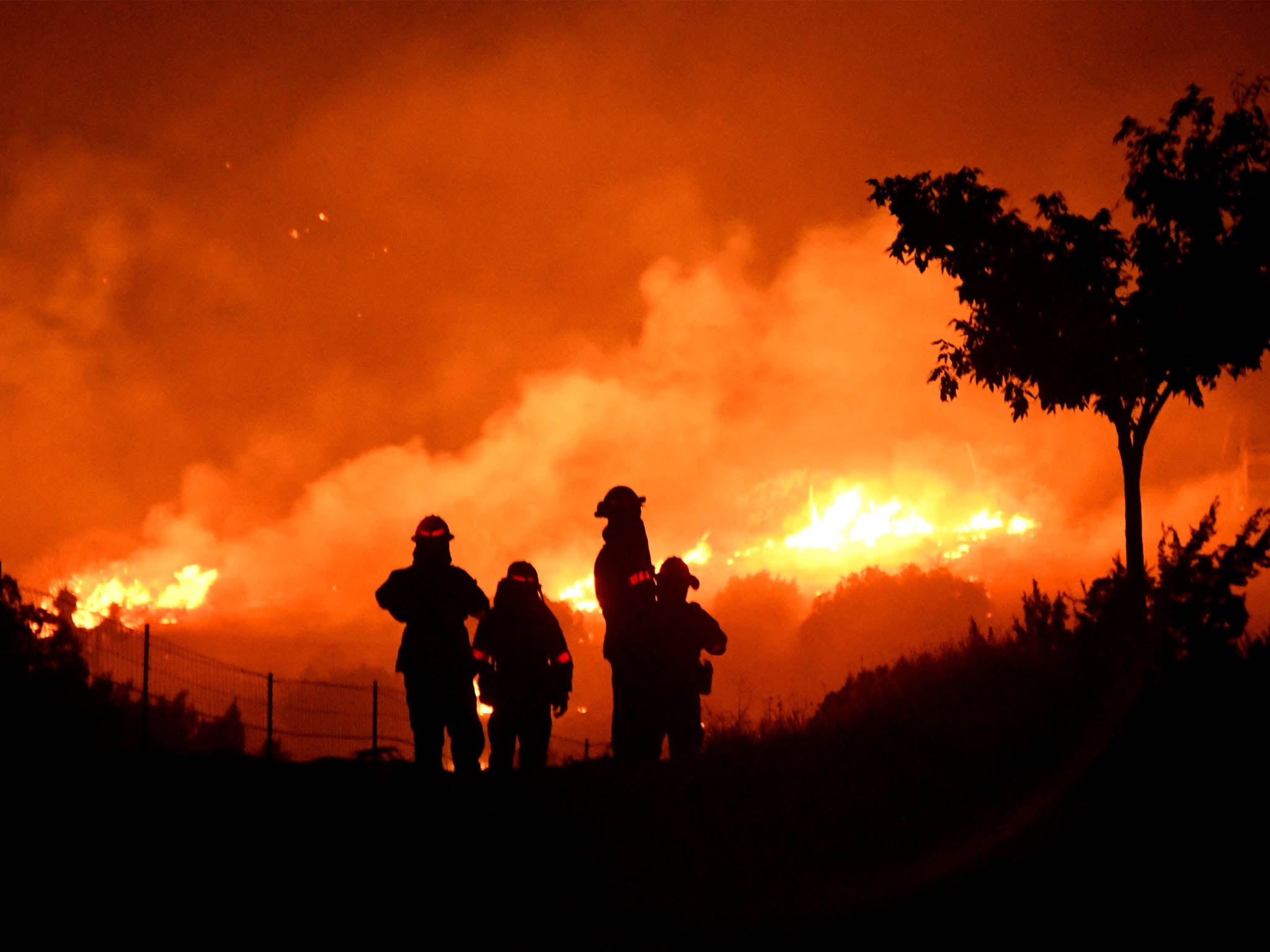 Los Angeles County firefighters keep watch on the Bobcat Fire as it burns through Juniper Hills, California, September, 2020