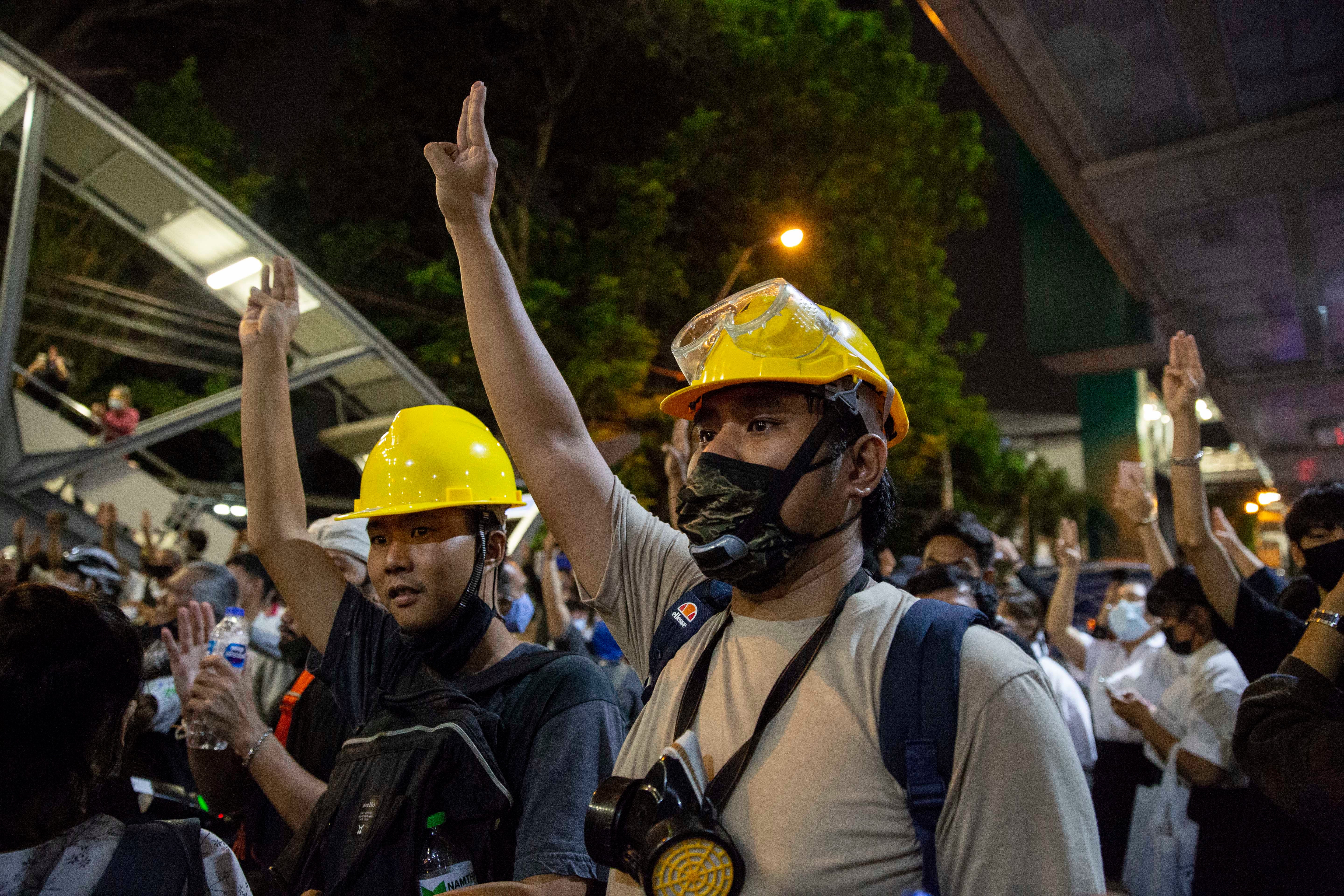 Thai pro-democracy protesters hold up a three finger salute at a rally in Bangkok on Monday