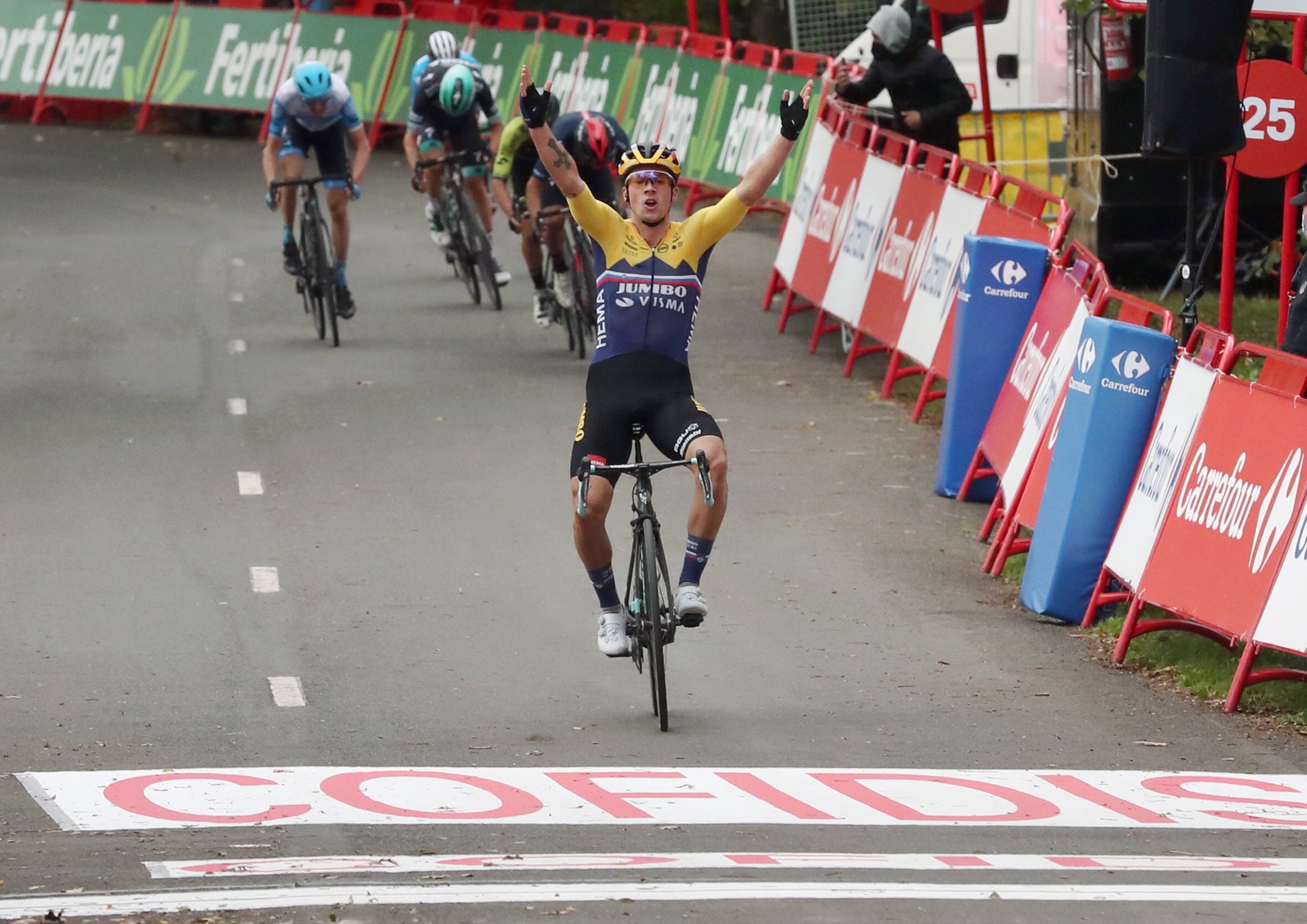 Primoz Roglic celebrates as he crosses the line to win stage one