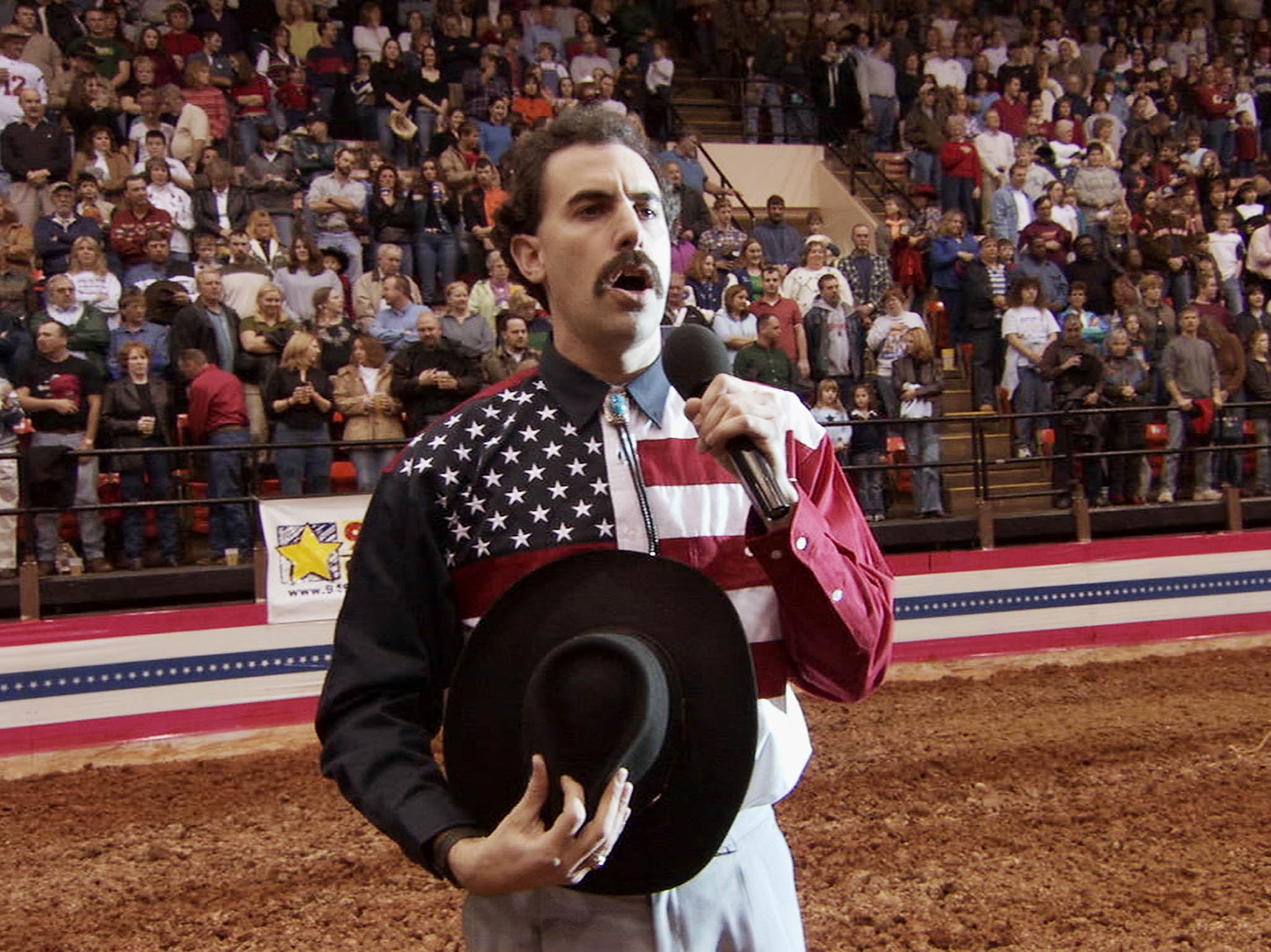 Very nice: Sacha Baron Cohen incites the fury of a crowd as he mangles the US anthem while singing at a rodeo