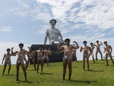 Borat statue air-lifted into Sydney, surrounded by mankini-clad men