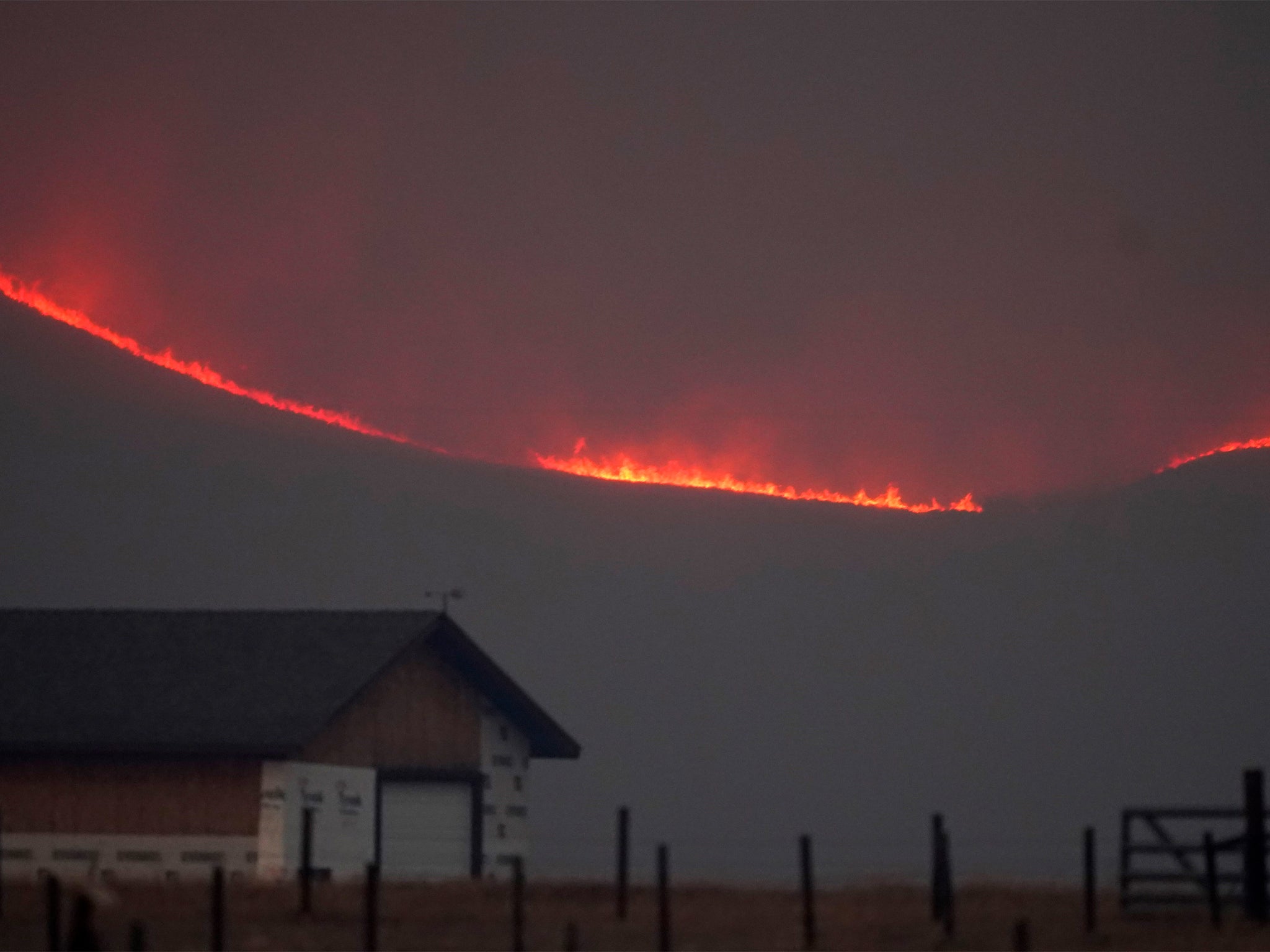 Flames rise from mountain ridges as a wildfire burns, 22 October 2020