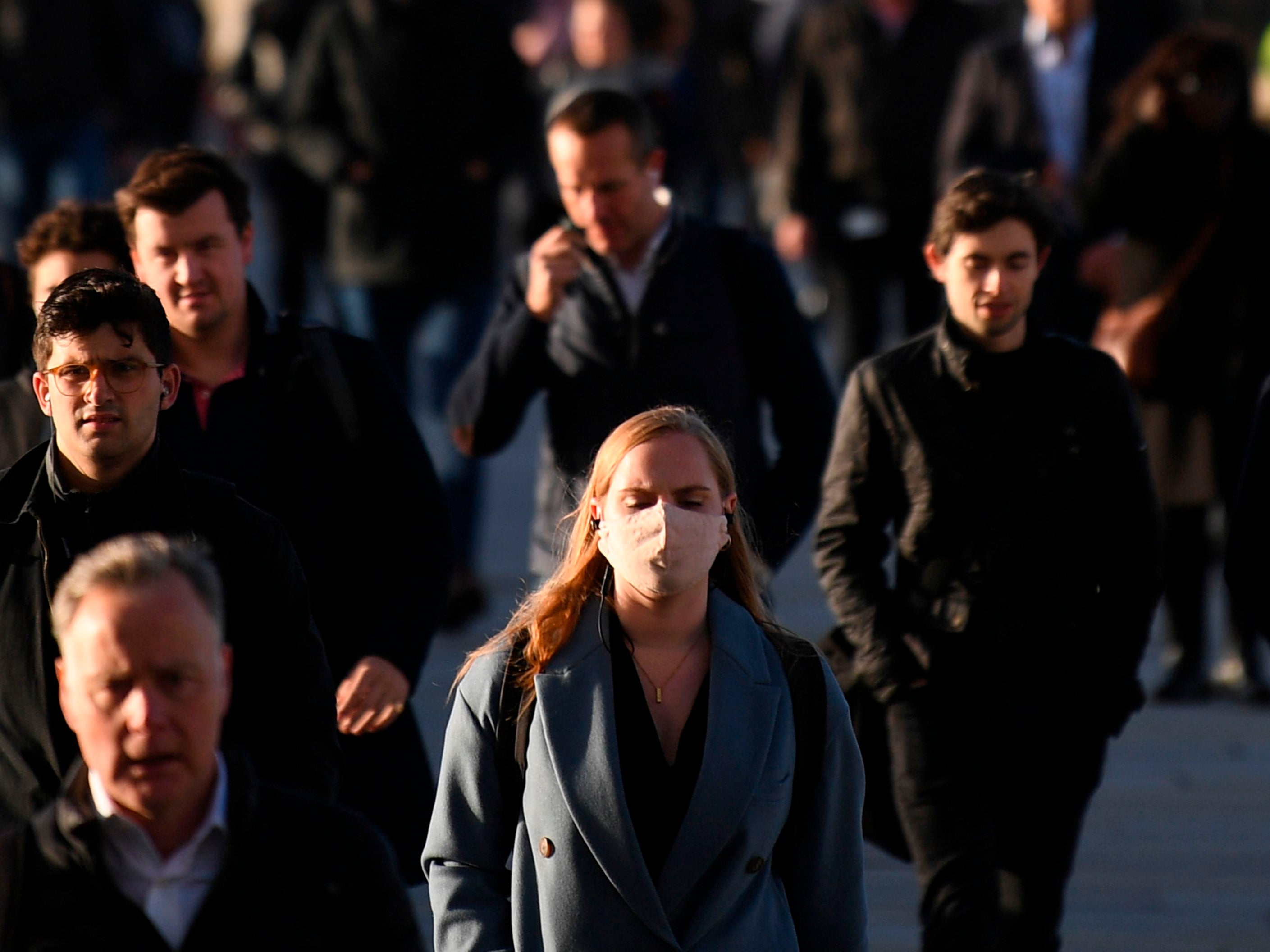 Commuters walk over London Bridge toward the City of London during the morning rush hour on 15 October 2020