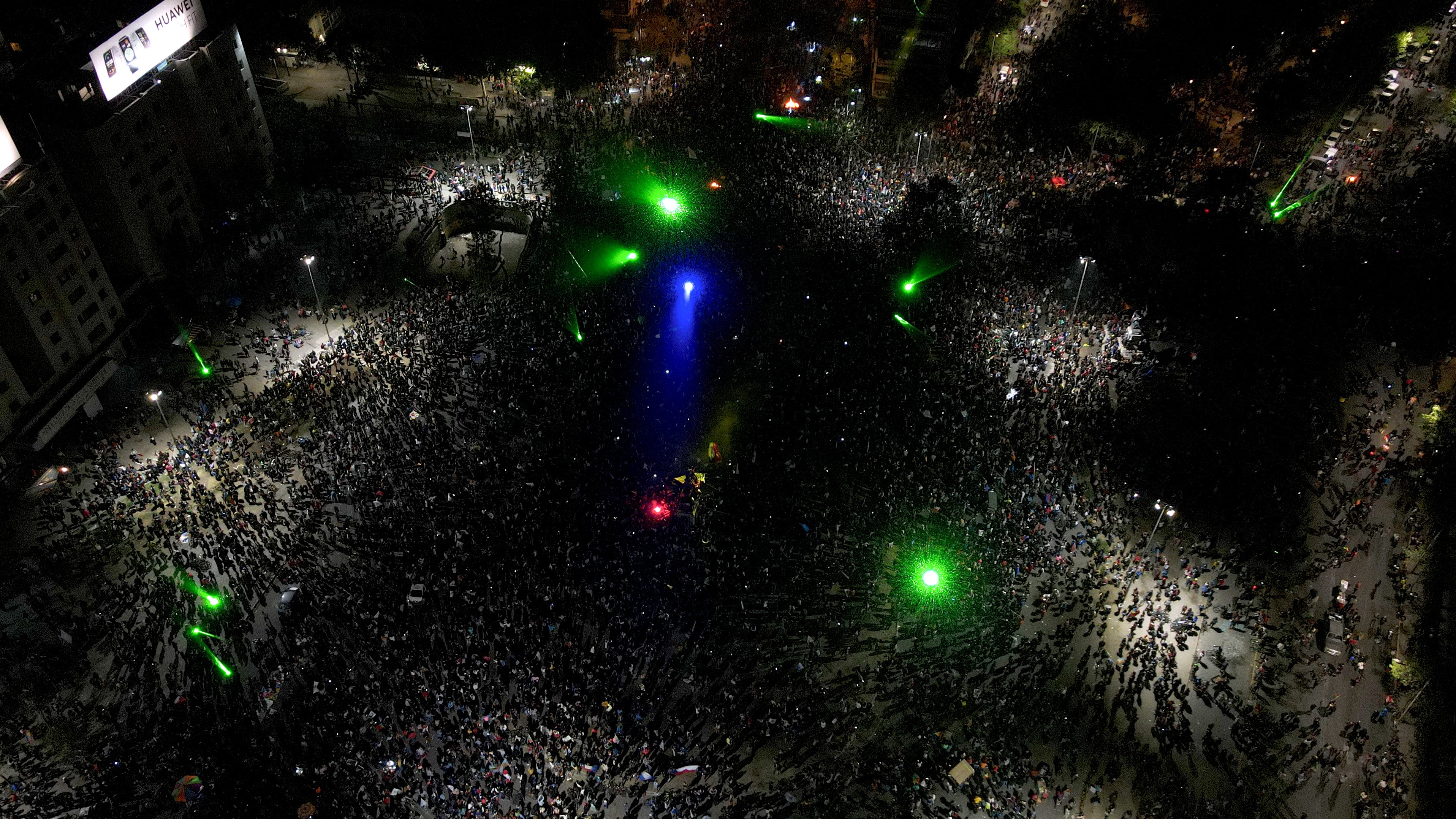 Thousands of people gather on the streets of Santiago, singing, dancing and lighting firecrackers