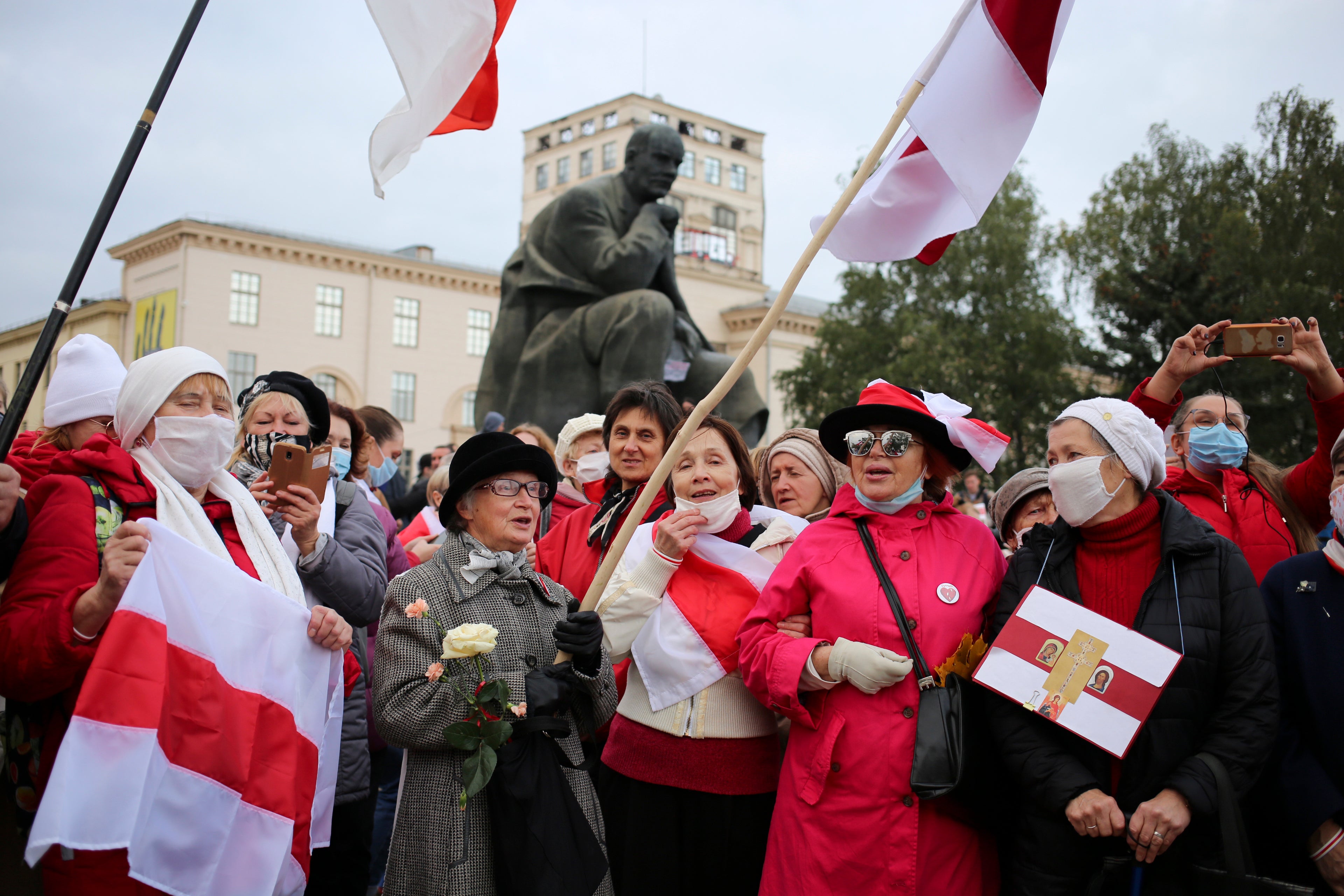 Old Belarusian flags are brandished by demonstrators in Minsk, Russia, protesting the Belarus presidential election results, on 26 October 2020