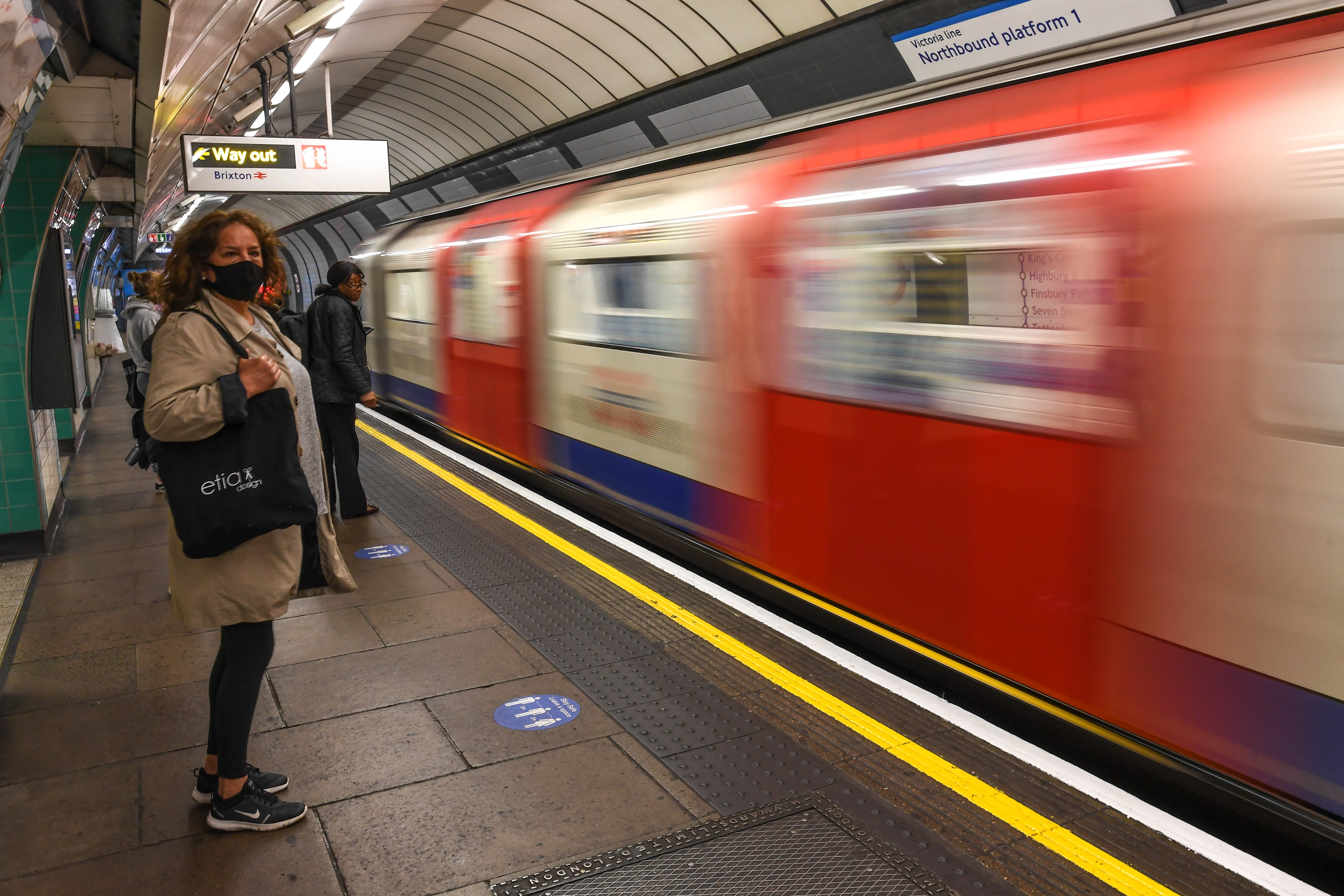 Commuters wear face masks as they use the London Underground