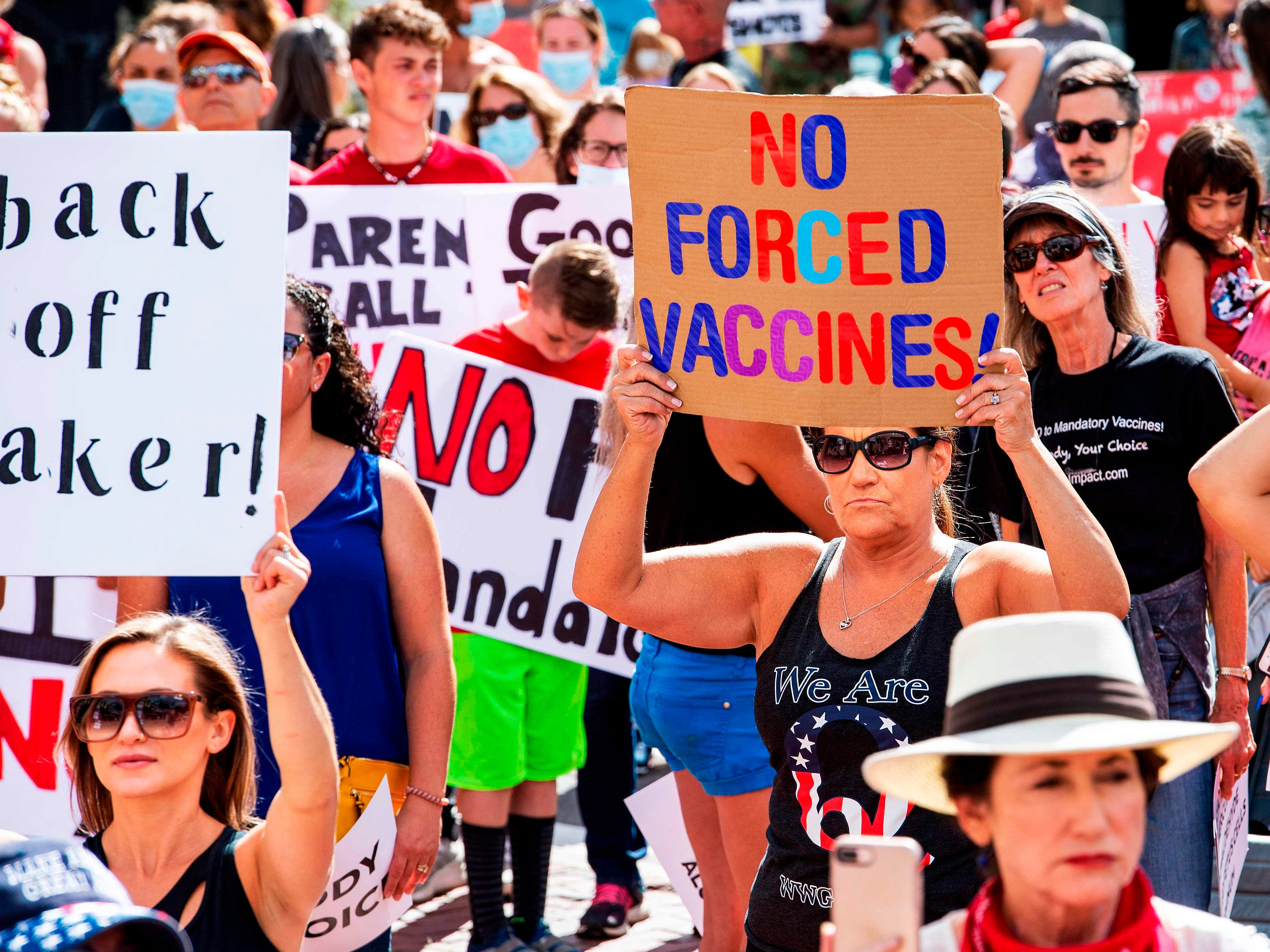 A woman with a QAnon shirt protesting a mandate from the Massachusetts Governor requiring all children, aged K-12, to receive a flu vaccine/shot to attend school for the 2020/2021 year outside the Massachusetts State House in Boston on August 30, 2020