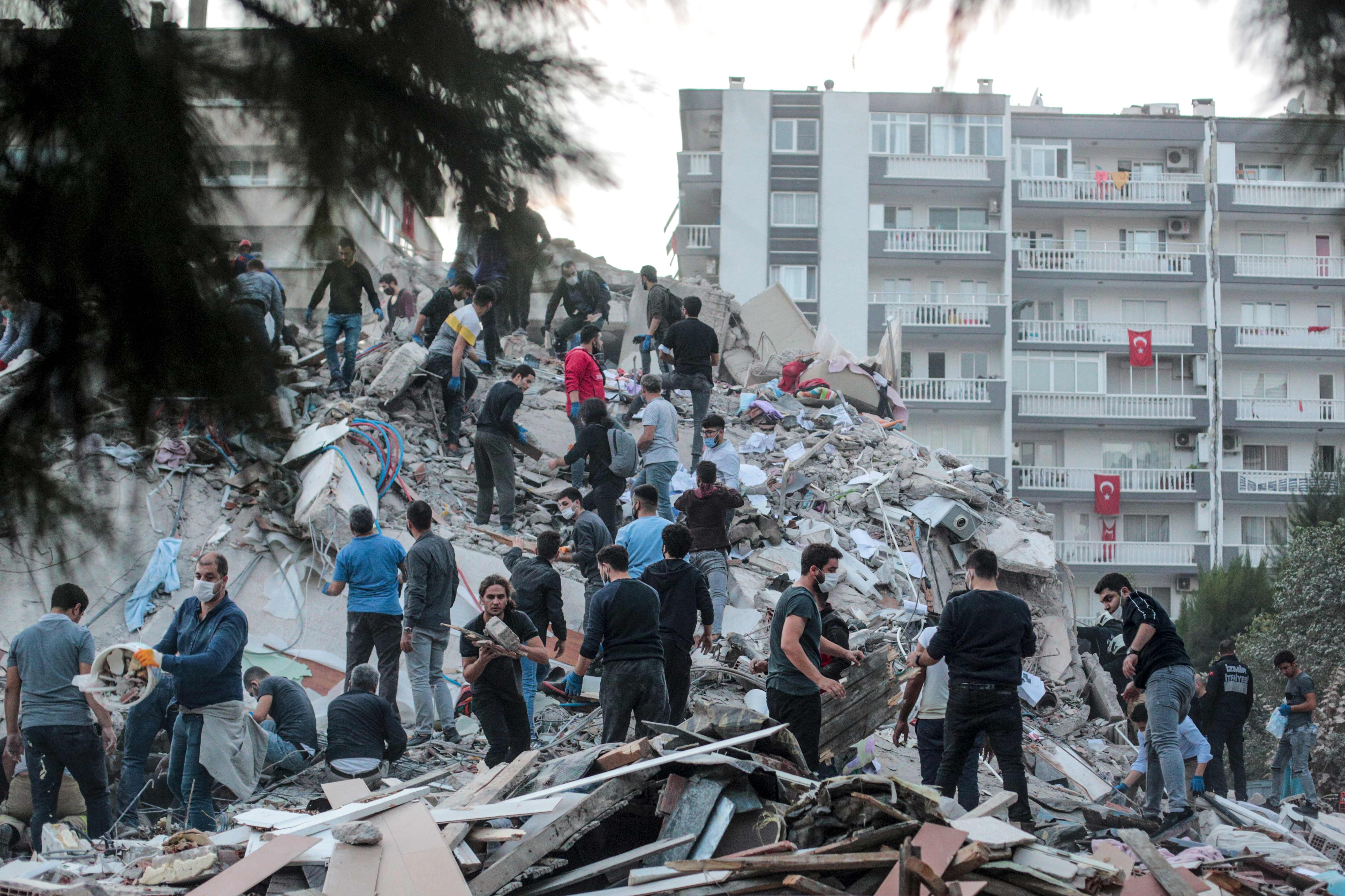 Volunteers clear rubble in Izmir (Photo by MERT CAKIR/AFP via Getty Images)