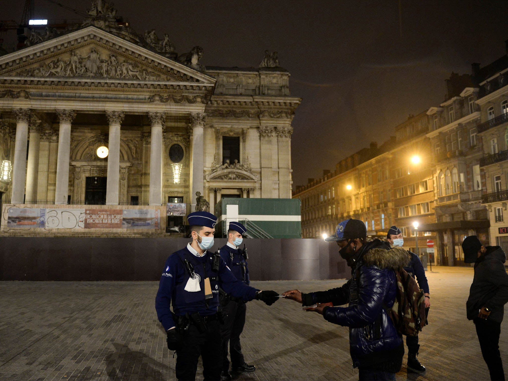 Police officers checking documents of men while patrolling in Brussels during curfew imposed by the Belgian government, 30 October, 2020