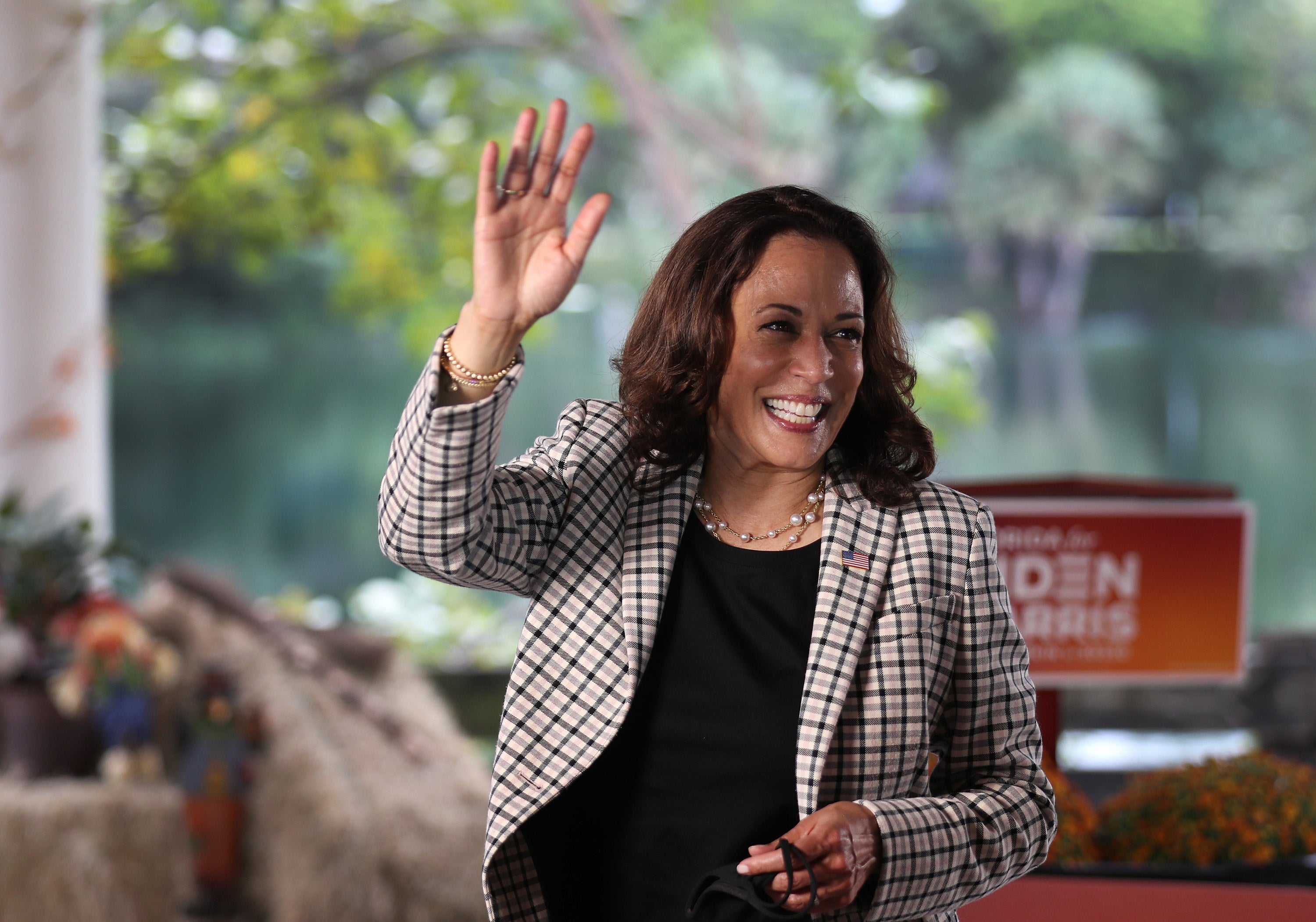 Kamala Harris waves wearing a set of pearls