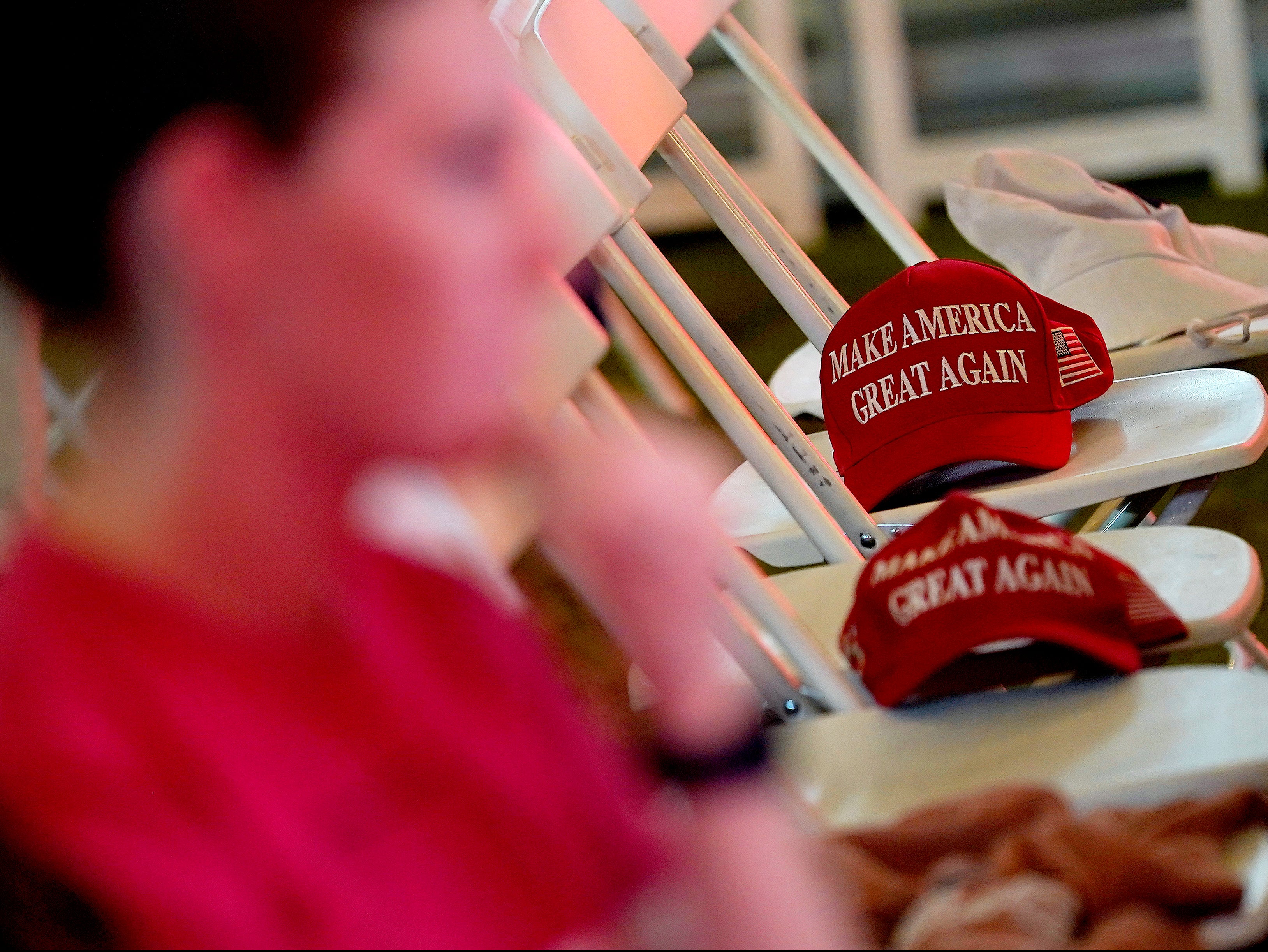 MAGA hats sit on empty seats during an election watch party, Tuesday, Nov. 3, 2020, in Chandler, Arizona