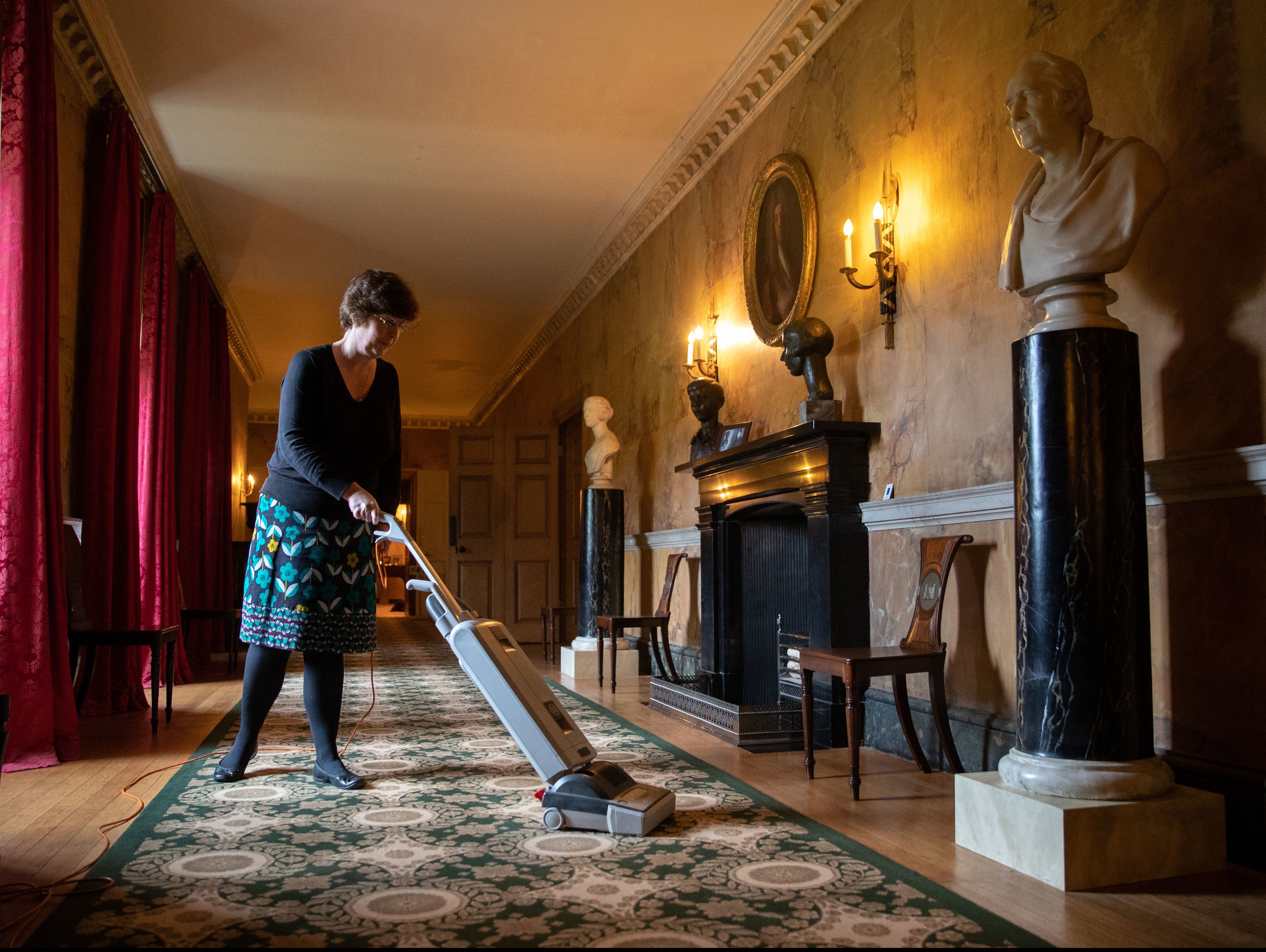 A staff member cleans the carpet at the National Trust’s Mottisfont Abbey in Hampshire