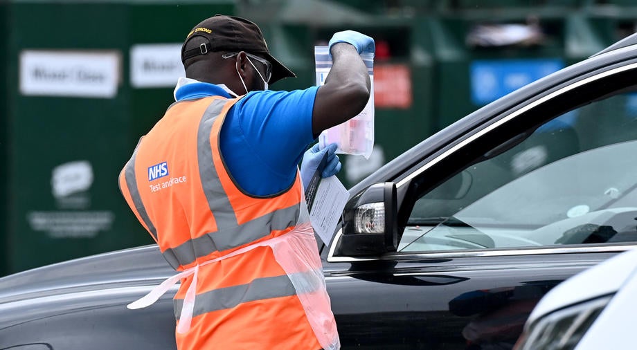 A staff member shows a kit to a customer at a self administered Covid-19 testing site in London earlier this year