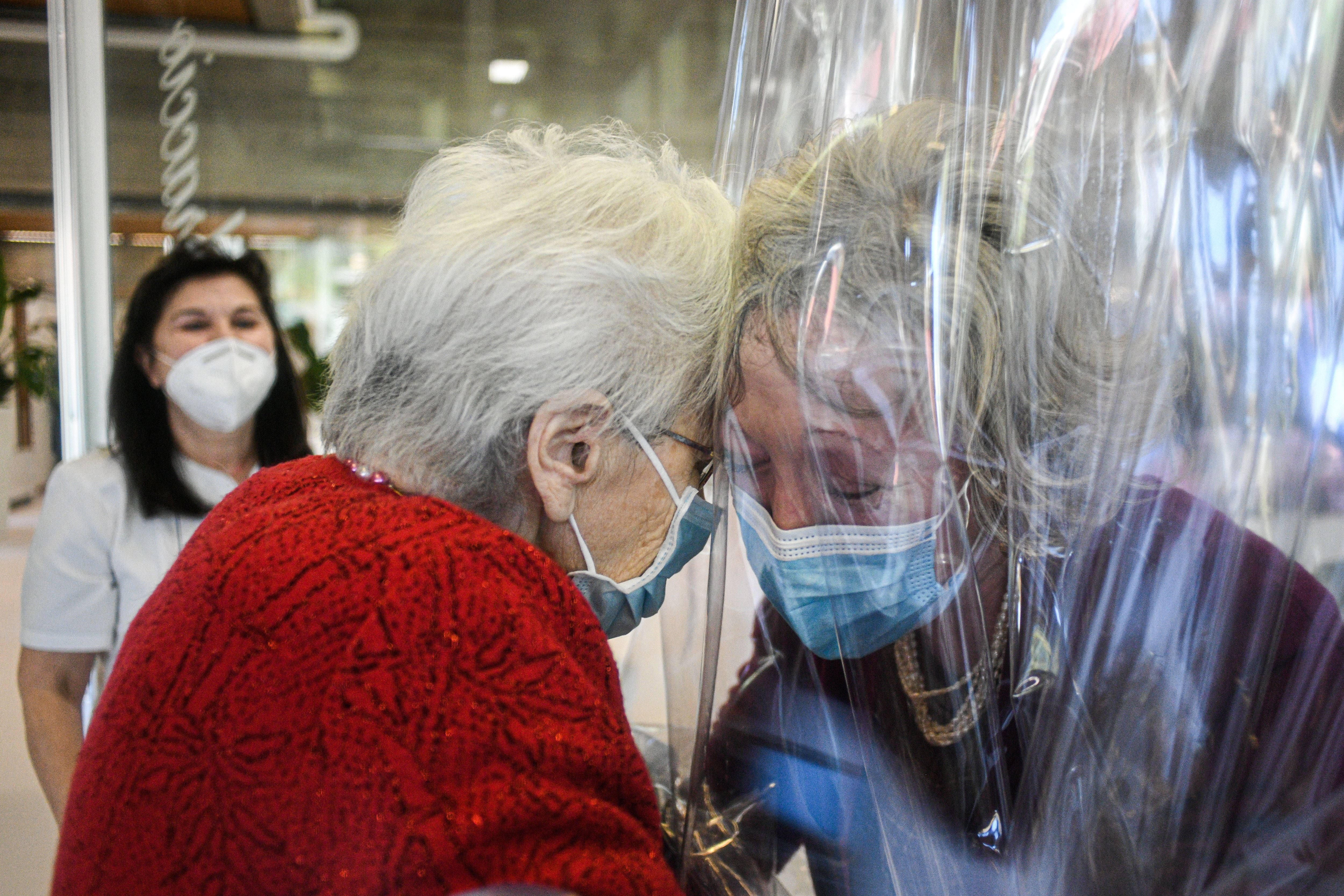 A resident (left) of the Domenico Sartor nursing home in Castelfranco Veneto, near Venice, hugs her visiting daughter