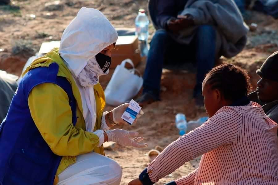 A humanitarian worker speaks with a survivor from a shipwreck off the coast of Libya near the port of al-Khums on November 12