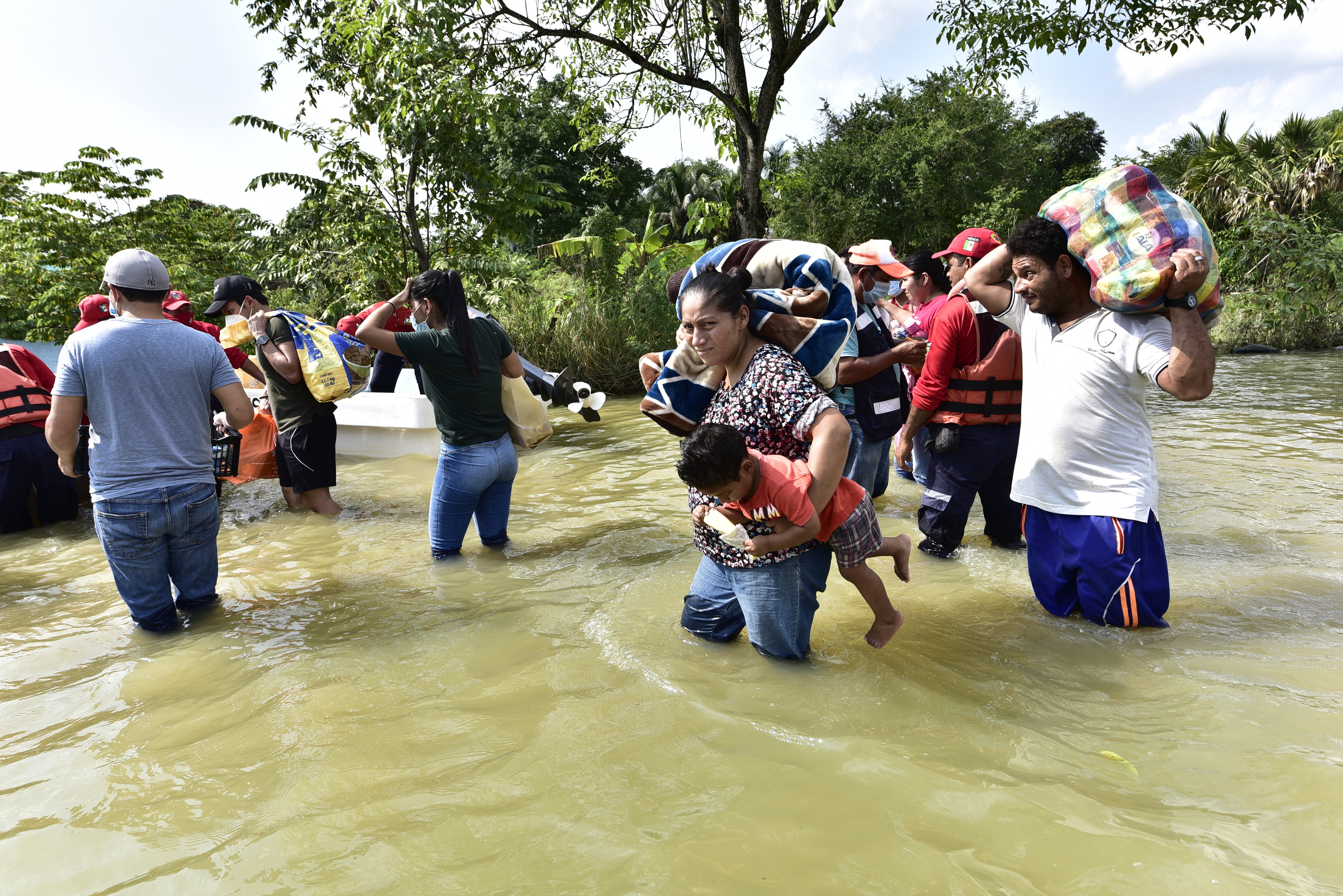 Inhabitants walk through an avenue flooded by heavy rains in Macuspana, Mexico (EPA/Jaime Avalos)