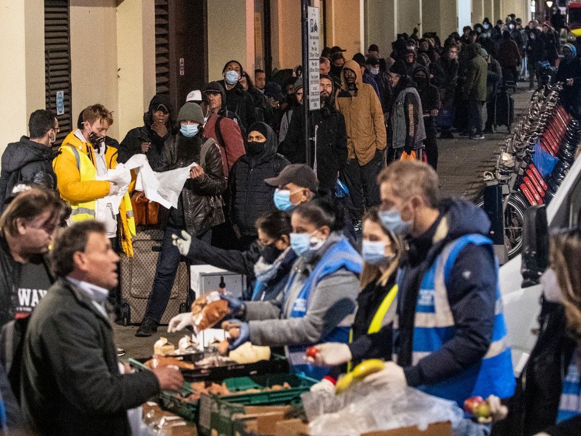 Volunteers from Shree Jalaram Mandir help a line of people on Agar Street in London on Friday night