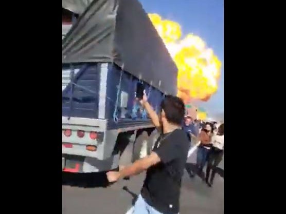 Bystanders flee a gas explosion that rocked a highway in Nayarit, Mexico and left at least 14 dead on Monday.