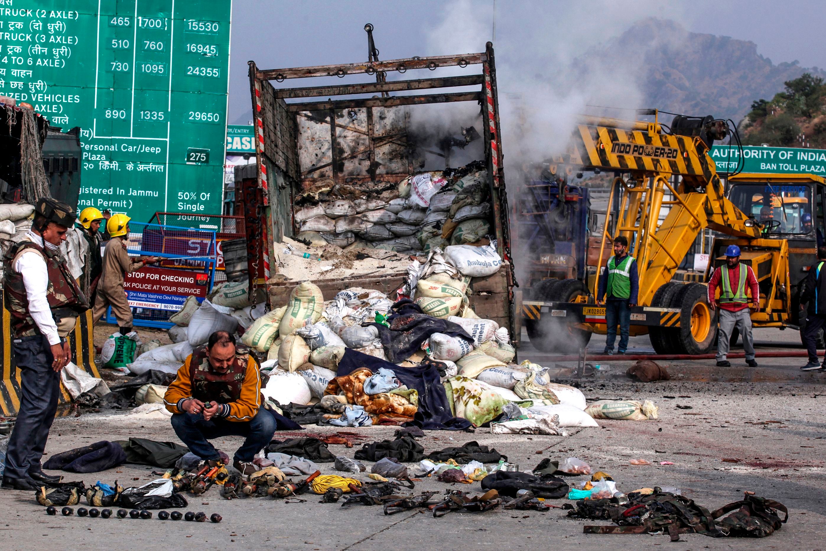 Security personnel inspect the site of an encounter between 4 alleged militants and security forces at Ban toll Plaza.