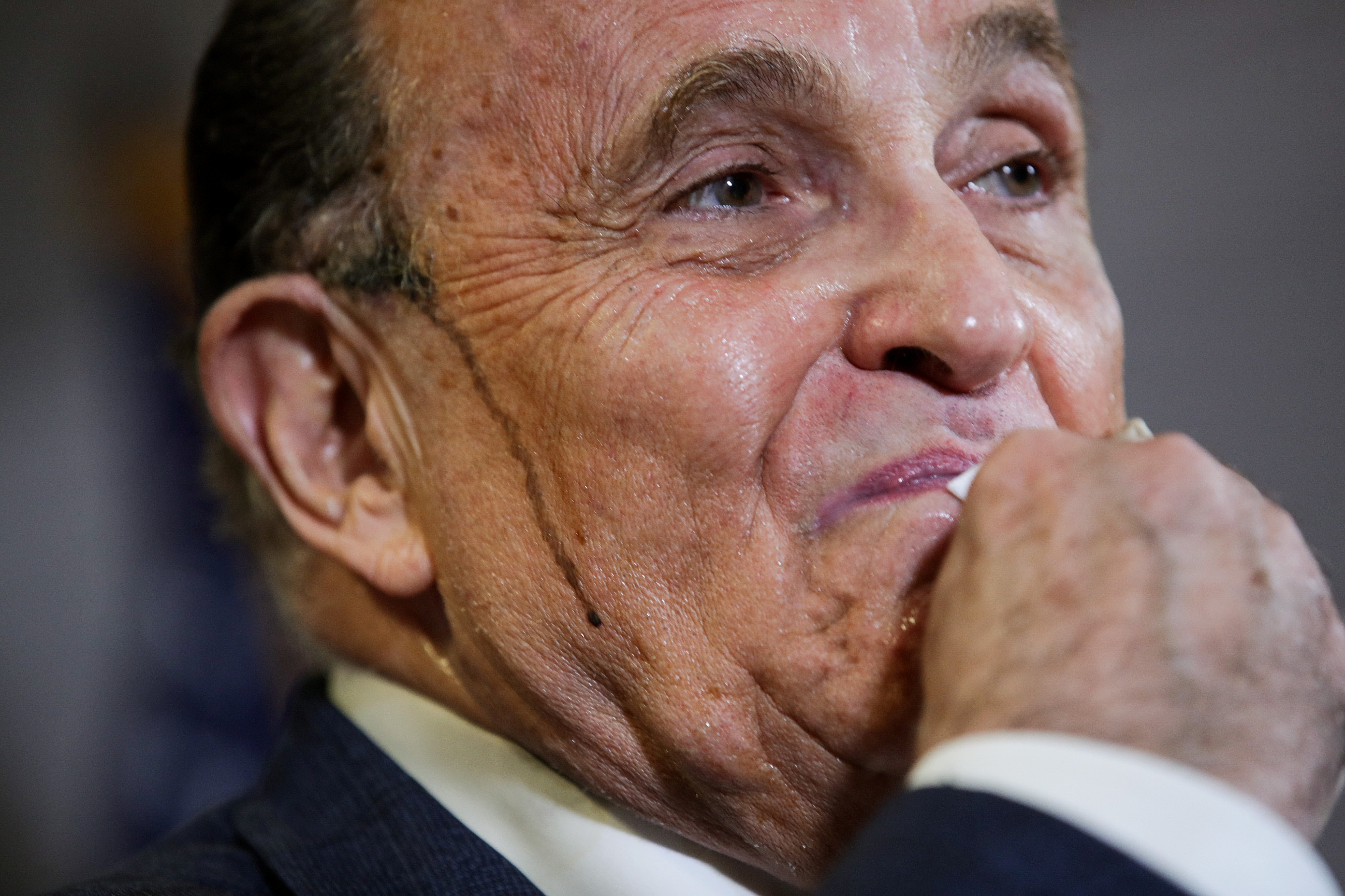 Former New York City Mayor Rudy Giuliani, personal attorney to U.S. President Donald Trump, wipes away sweat as he speaks about the 2020 U.S. presidential election results during a news conference in Washington, U.S., November 19, 2020. REUTERS/Jonathan Ernst