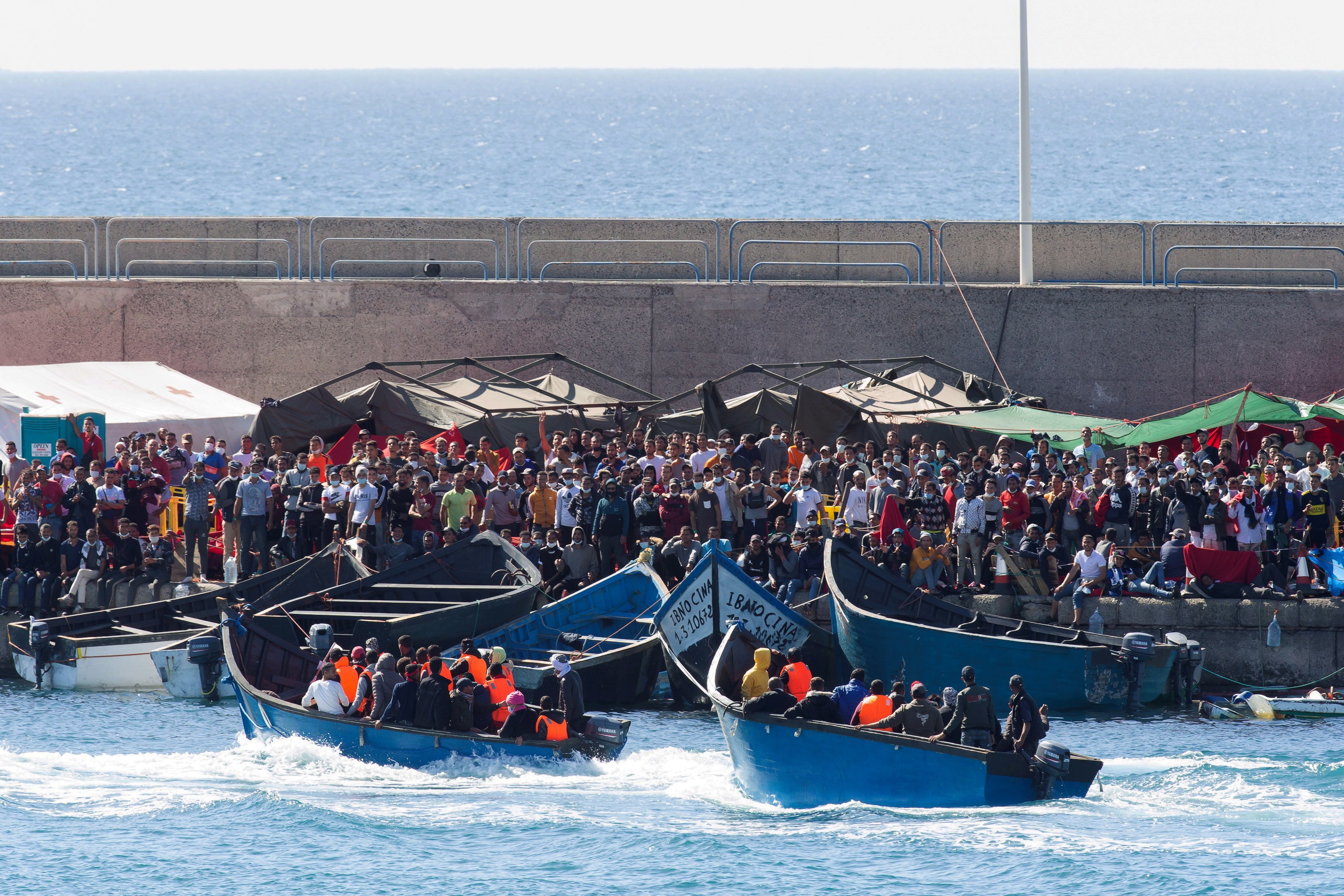 Two boats (C) with migrants are welcomed by other migrants upon their arrival at Arguineguin port, Gran Canaria island, earlier this month (EPA/QUIQUE CURBELO)