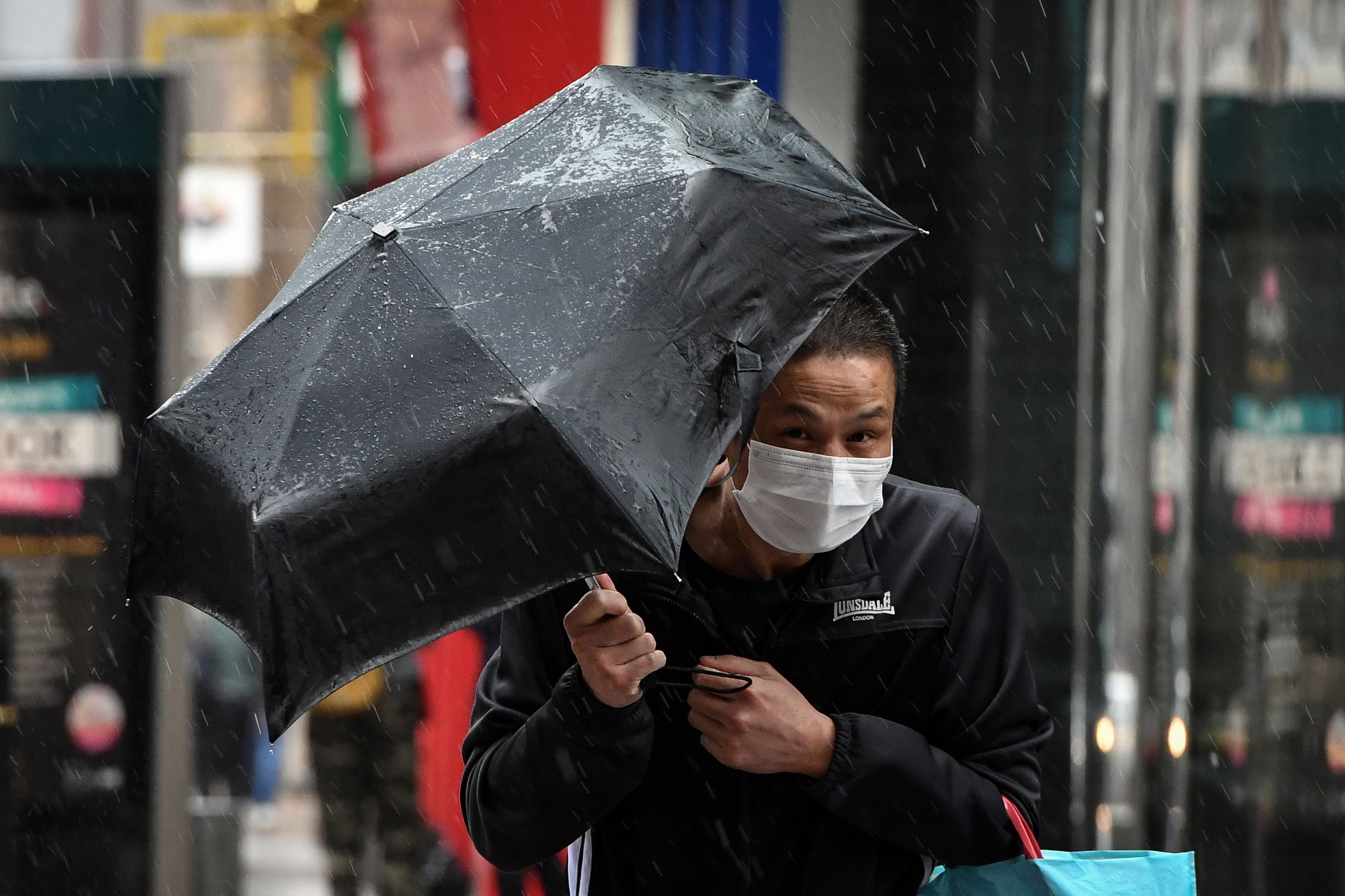 A pedestrian struggles against the wind in Glasgow city centre