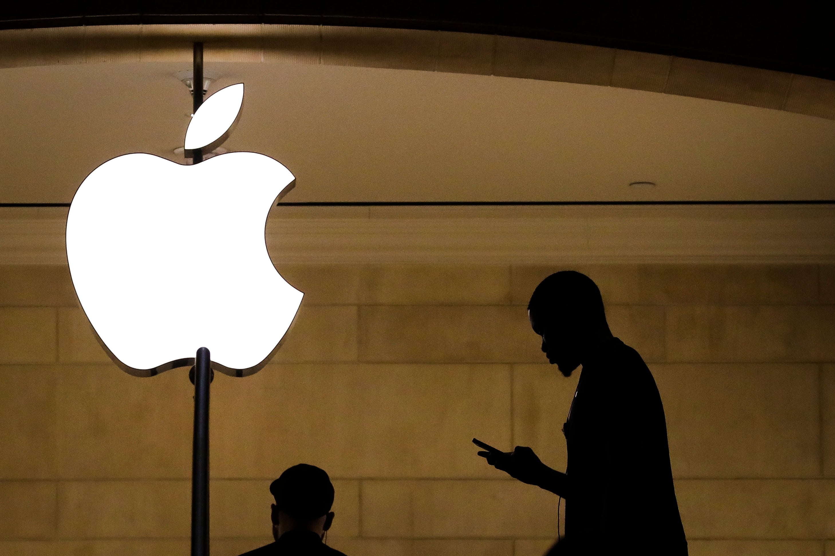 A man checks his phone in an Apple retail store New York