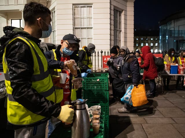 <p>Homeless people collect donated food provided by the Rhythms of Life charity near Trafalgar Square, London</p>