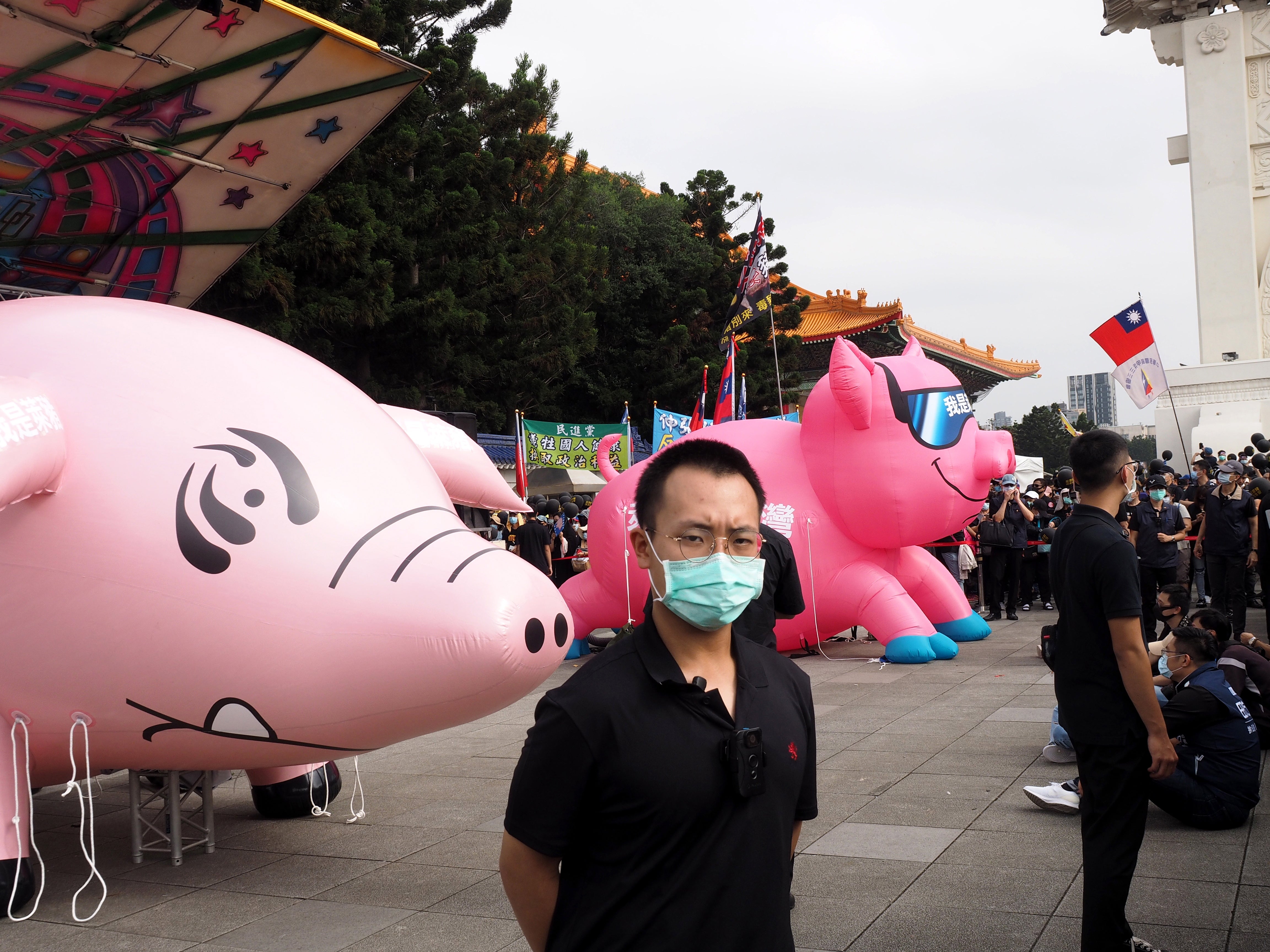 Men maintain order before protesters march to the Presidential Office Building in Taipei, which this year focused on the government’s proposed import of US