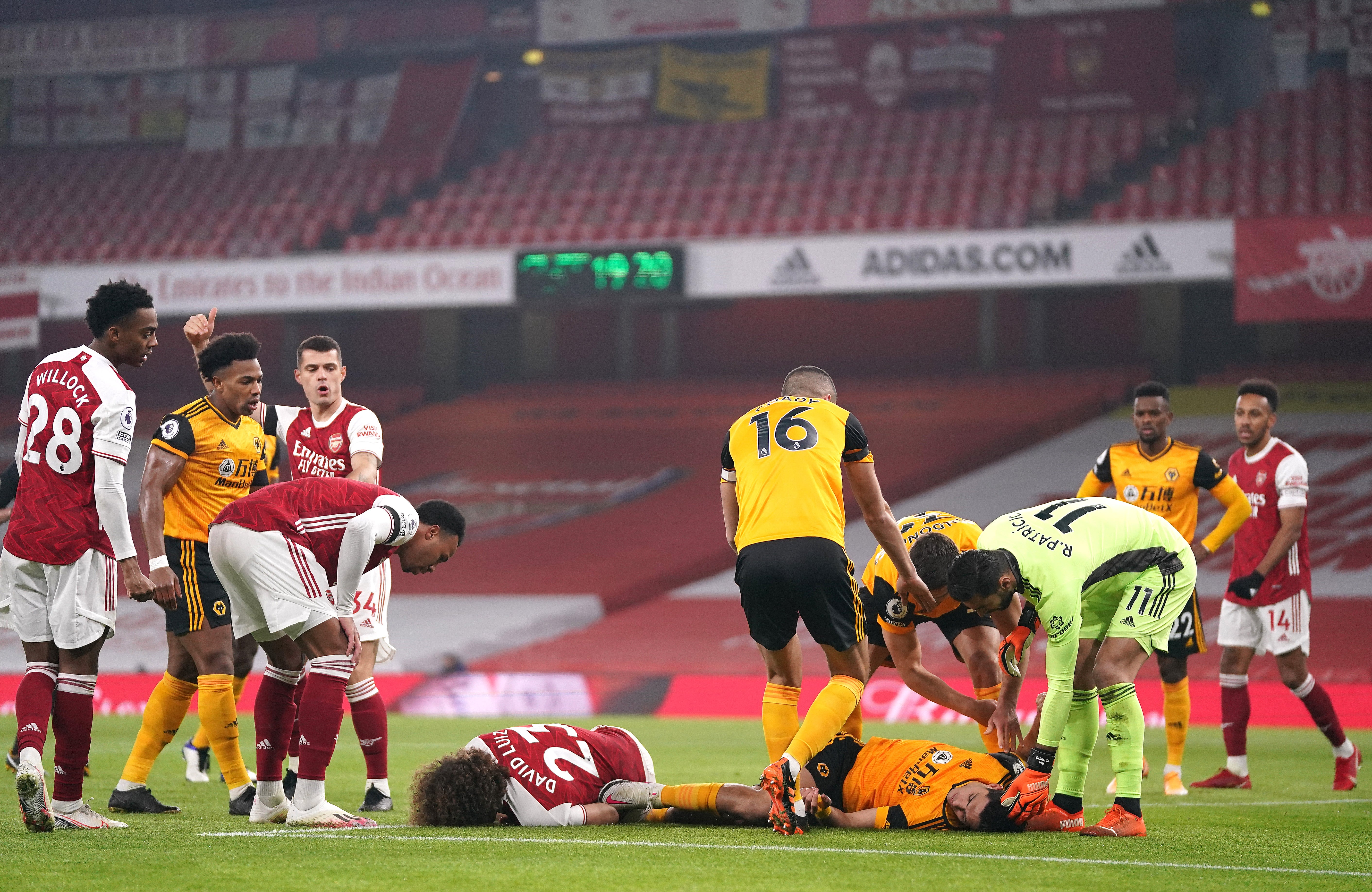 LONDRES, INGLATERRA - 29 DE NOVIEMBRE: David Luiz del Arsenal y Raúl Jiménez del Wolverhampton Wanderers yacen lesionados después de una colisión durante el partido de la Premier League entre el Arsenal y el Wolverhampton Wanderers en el Emirates Stadium el 29 de noviembre de 2020 en Londres, Inglaterra. Los estadios deportivos en todo el Reino Unido siguen bajo estrictas restricciones debido a la pandemia del Coronavirus, ya que las leyes de distanciamiento social del gobierno prohíben a los aficionados dentro de las sedes, lo que hace que los partidos se jueguen a puerta cerrada.