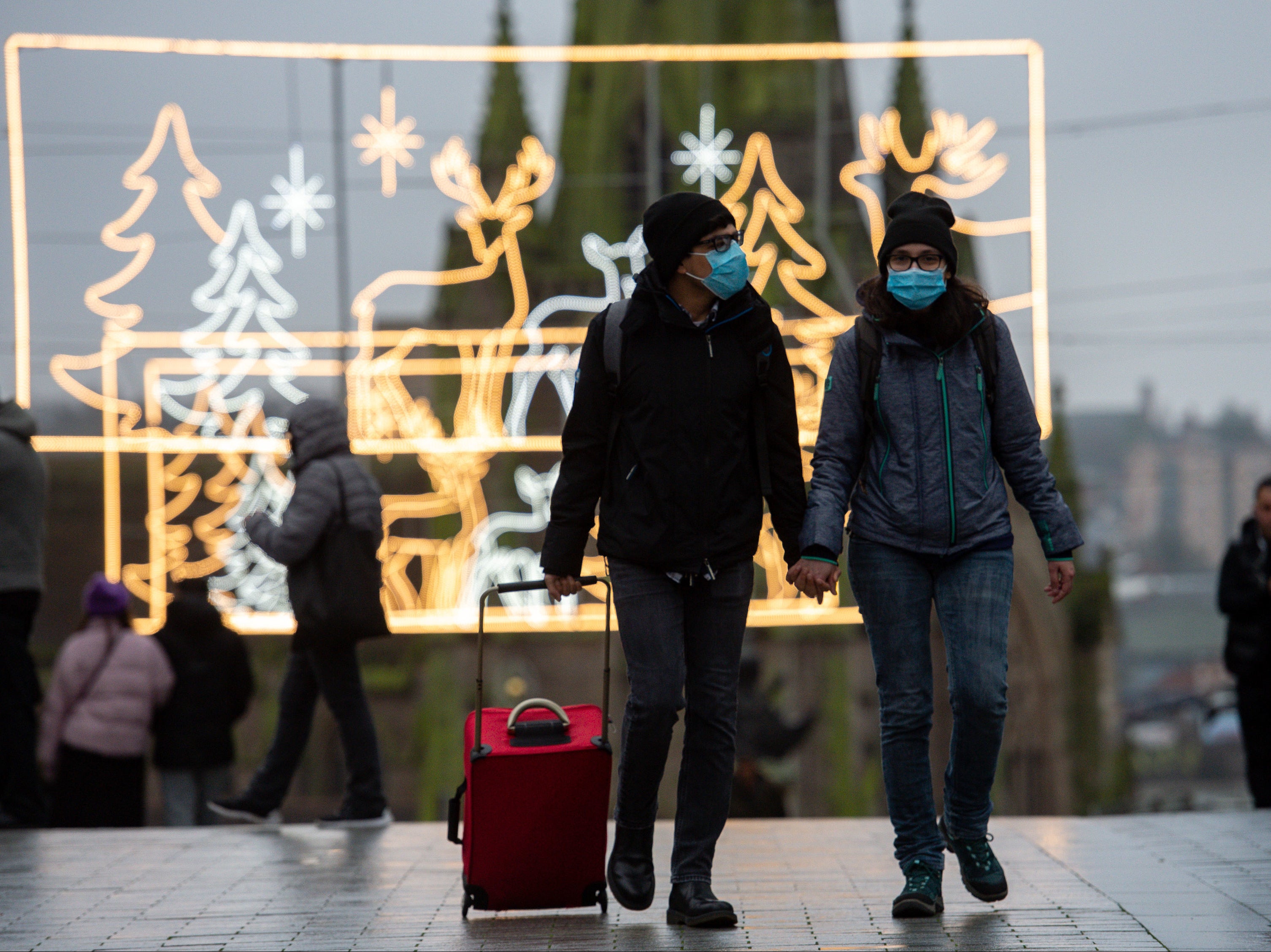 A man walks amongst festive lighting by the Bullring shopping centre in Birmingham