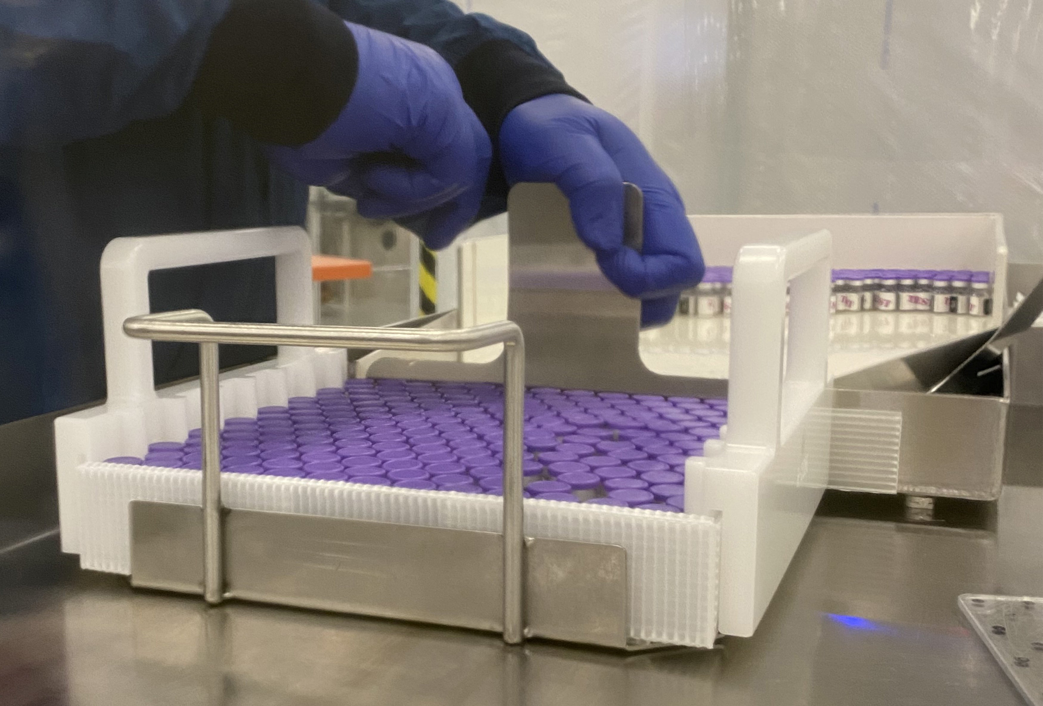 An employee places vials with the coronavirus disease vaccine at the Pfizer manufacturing facility in Kalamazoo, Michigan.